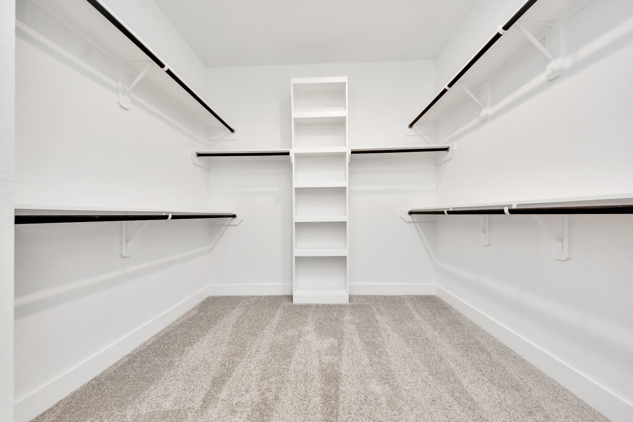 Walk-in closet that epitomizes luxury and practicality. This generously sized space features built-in shelving, offering abundant room for impeccable organization. High ceilings and recessed lighting create a bright and welcoming ambiance.