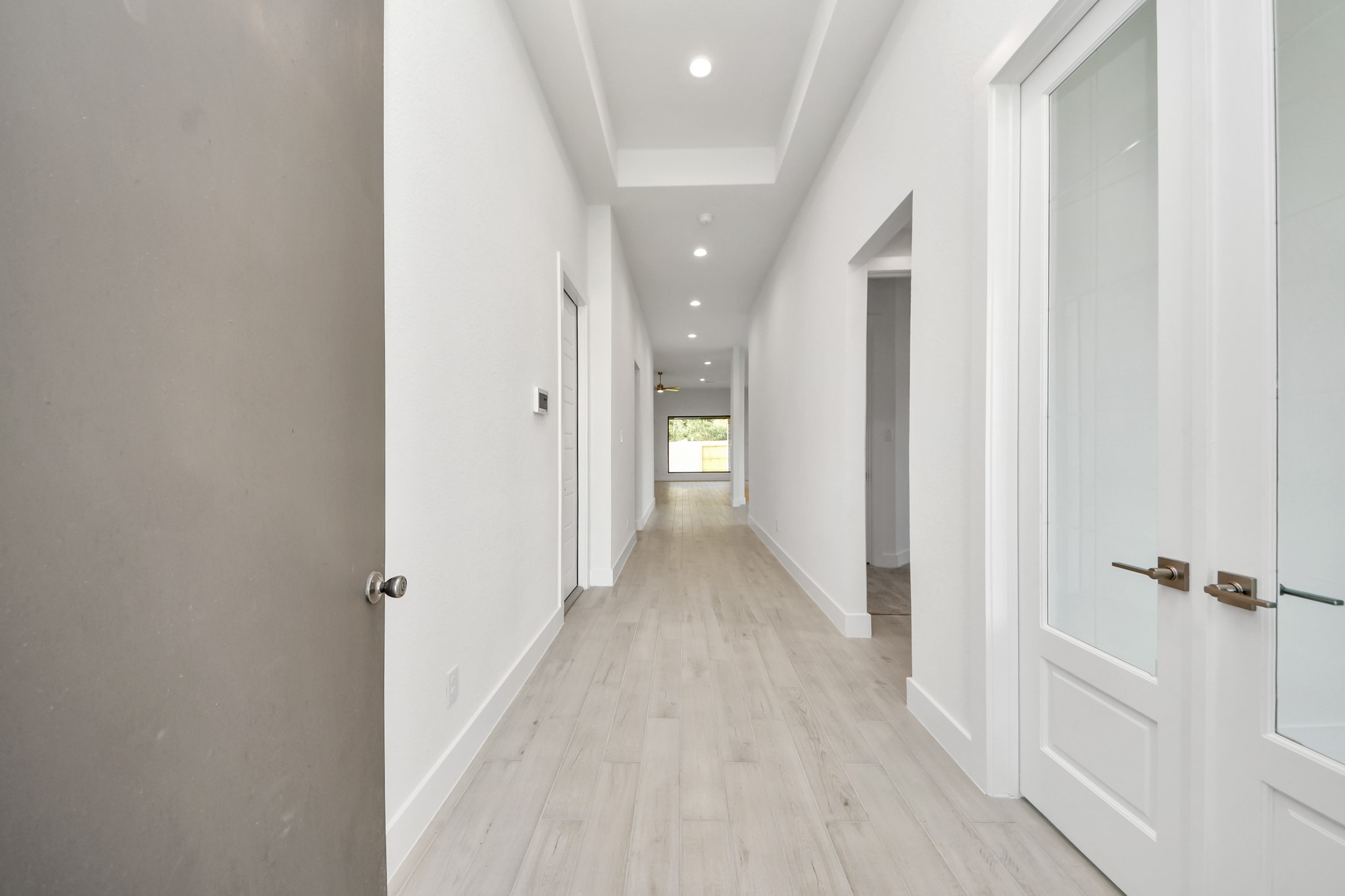 As you step into the threshold of this luxurious home, you'll soon be welcomed by an elegant glass door (to be installed). Inside, soaring ceilings amplify the spaciousness, while the refined wood-look tile flooring and oversized baseboards exude sophistication and charm.