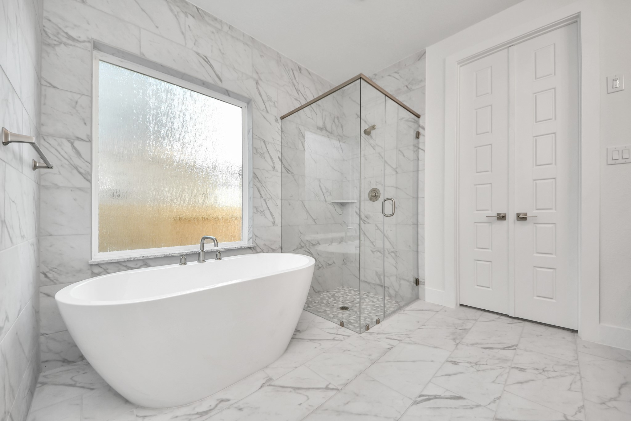 Indulge in a spa-like retreat within the confines of this primary bathroom. Delight in a spacious walk-in shower enveloped in stylish tile surround, unwind in a separate garden tub adorned with custom detailing.