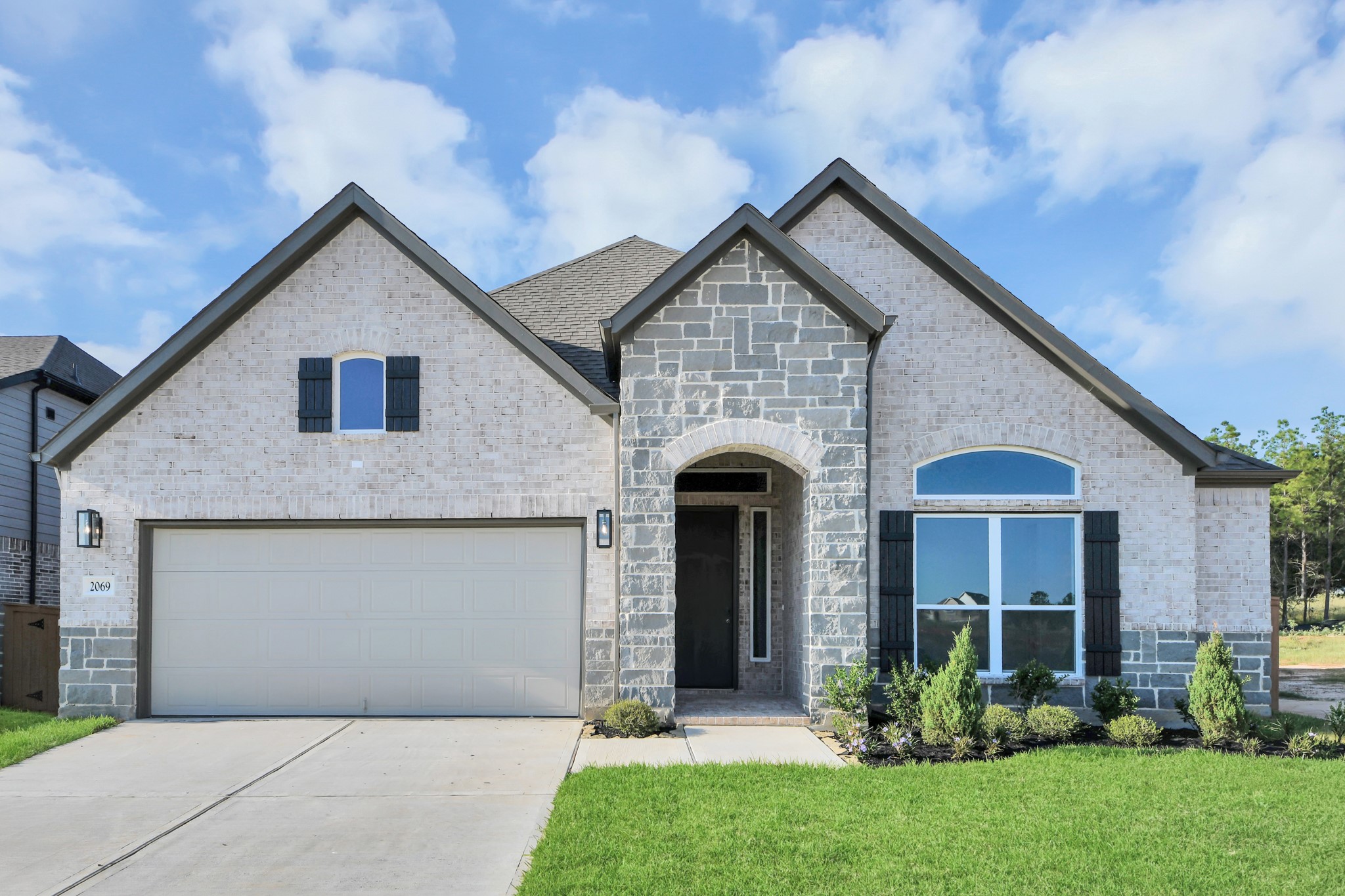 The residence features a practical 2-car garage complemented by a generous driveway, ensuring abundant space for parking needs.