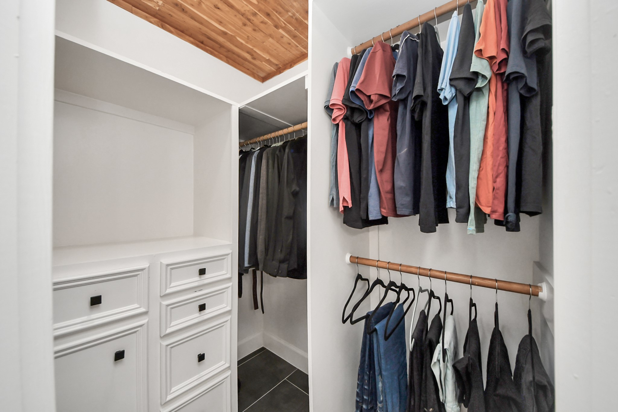 Walk-in closet for him with built-ins.