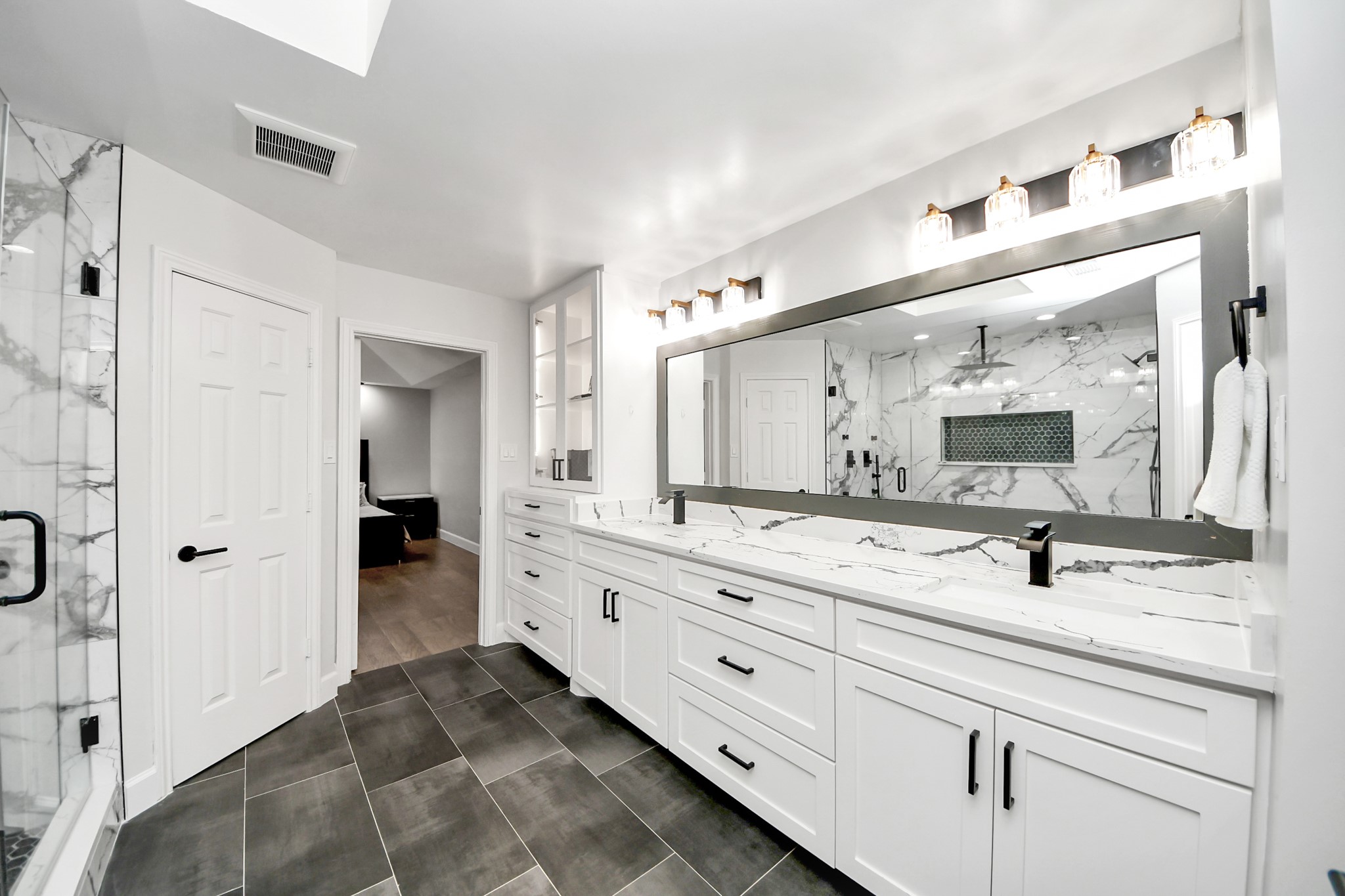 Grand vanity with dual sinks, plenty of counter space, and under-vanity storage.