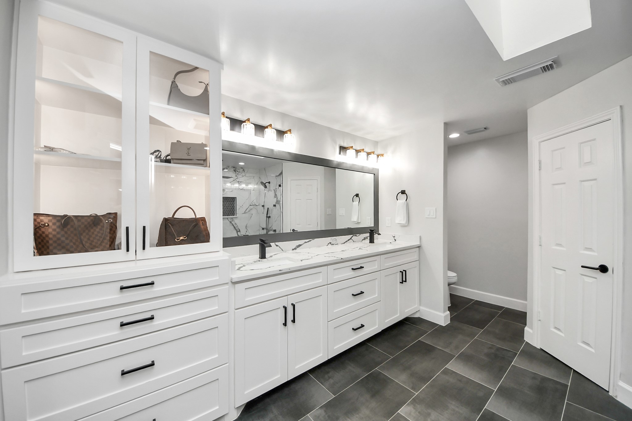 Custom wardrobe-style cabinetry with glass-front uppers.