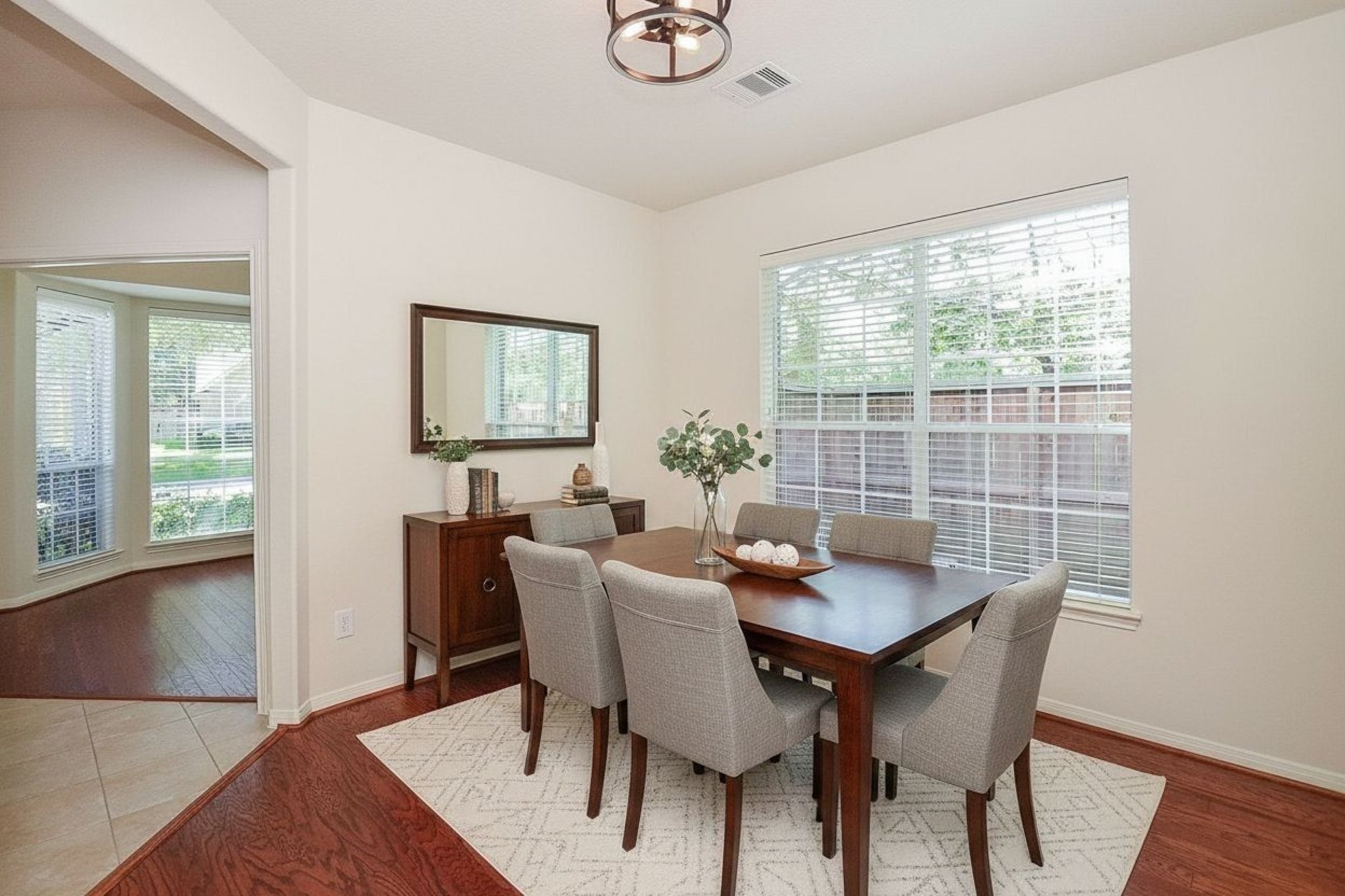 Bright and inviting, this virtually staged dining room offers an abundance of natural light through large windows, creating the perfect setting for memorable gatherings.