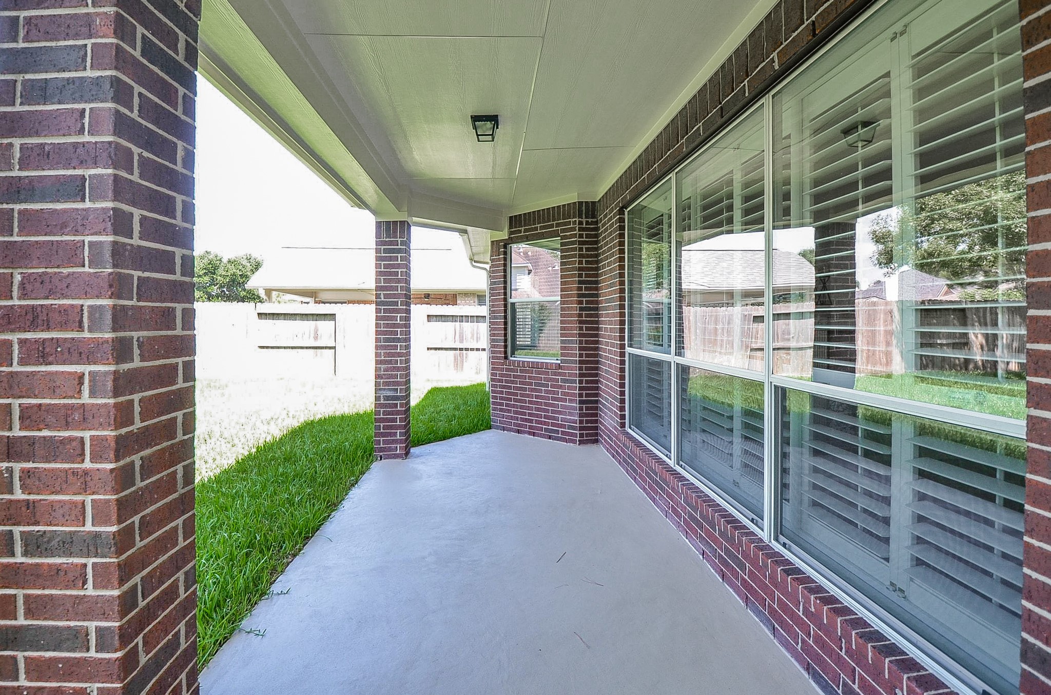Charming home in a tranquil neighborhood with a spacious covered patio, ideal for relaxation and entertaining amidst lush greenery.