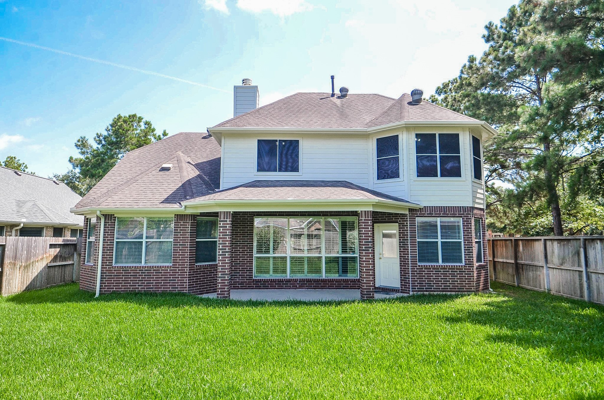 Spacious home nestled on a large, lush lot with mature trees and a fenced backyard, offering ample privacy and outdoor space.