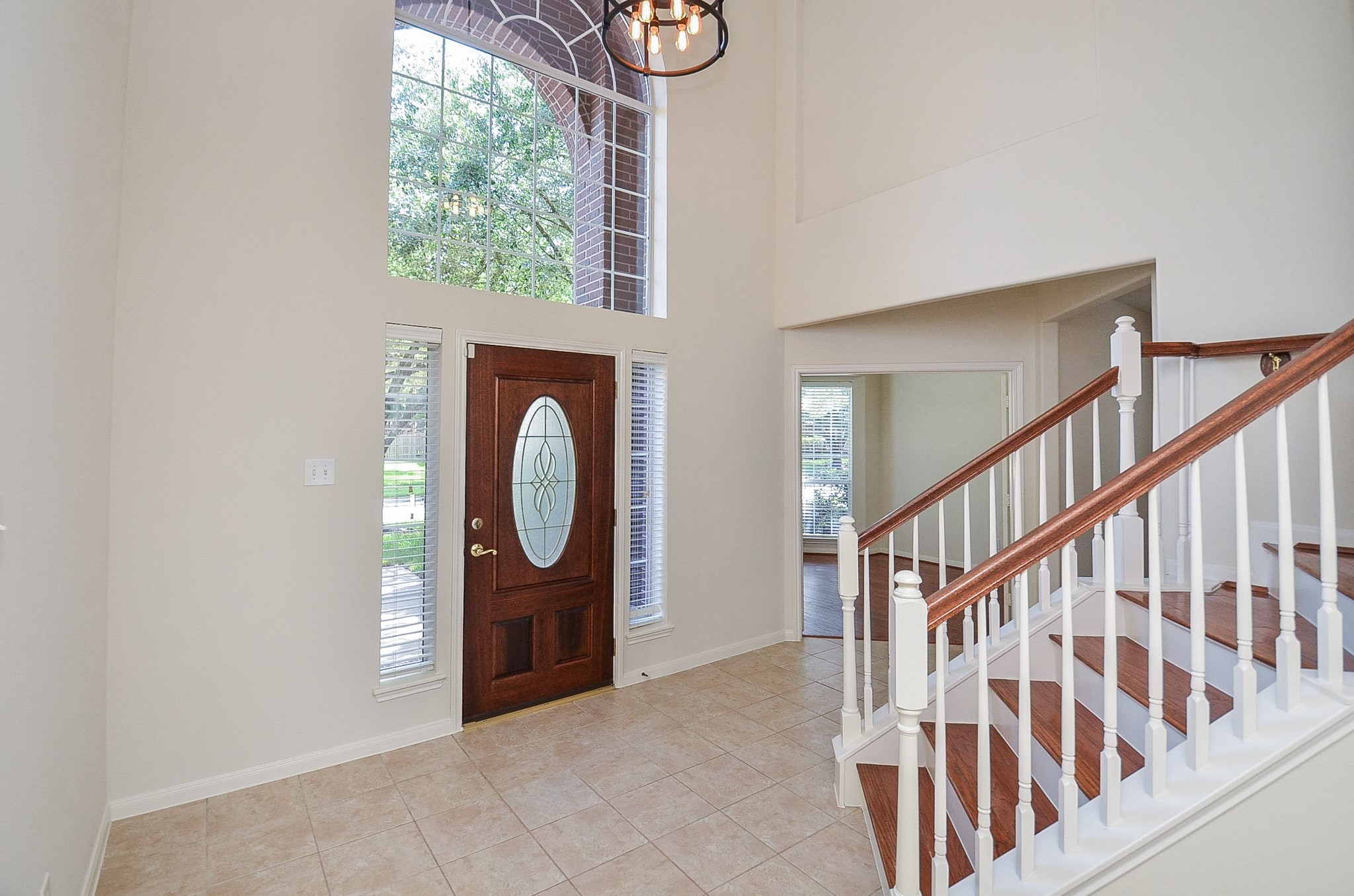 Experience elegance with a grand entryway leading to a bright, inviting room featuring French doors and expansive bay windows.