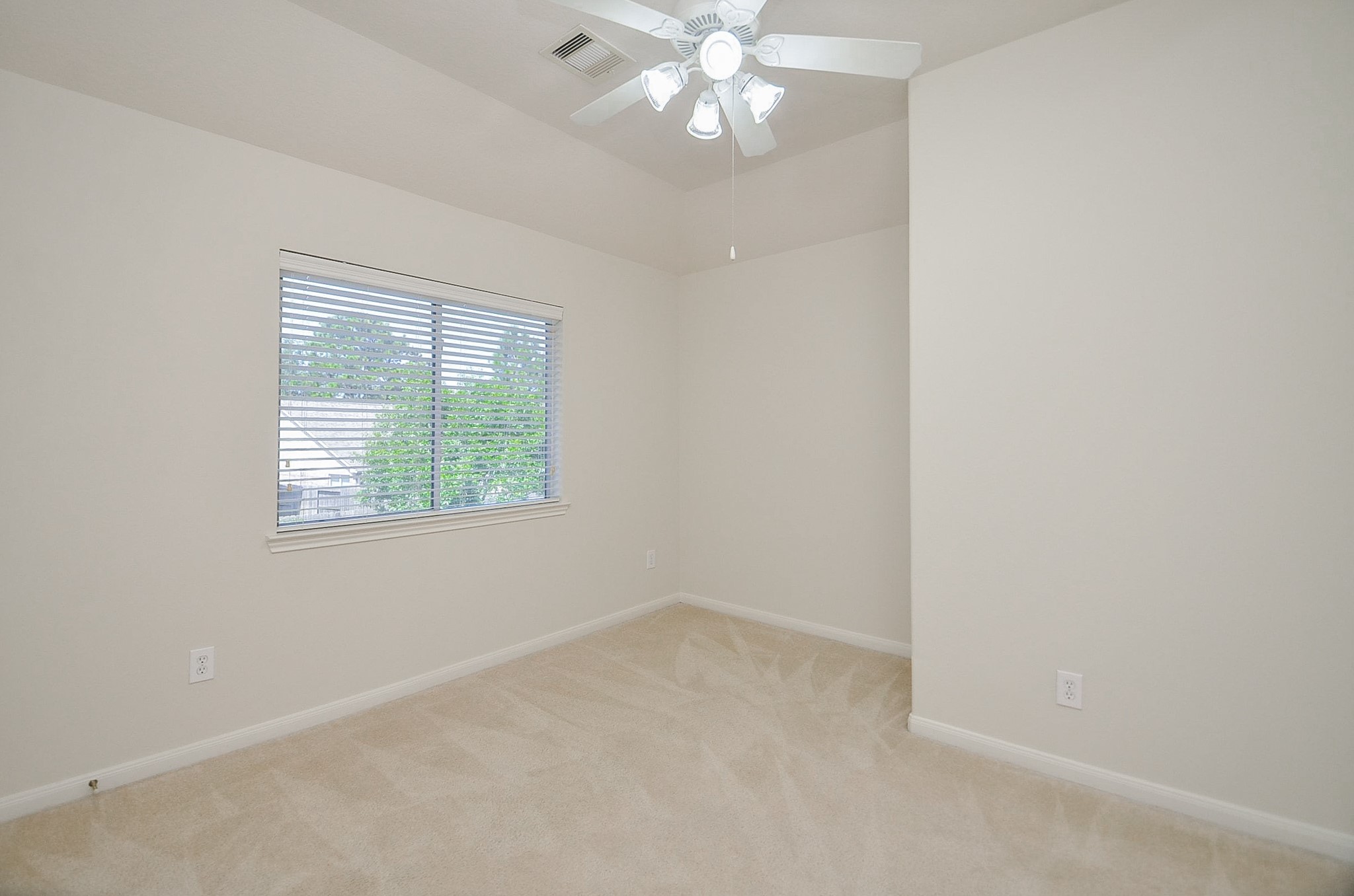 The second bedroom three offers a cozy retreat with abundant natural light and serene backyard views.
