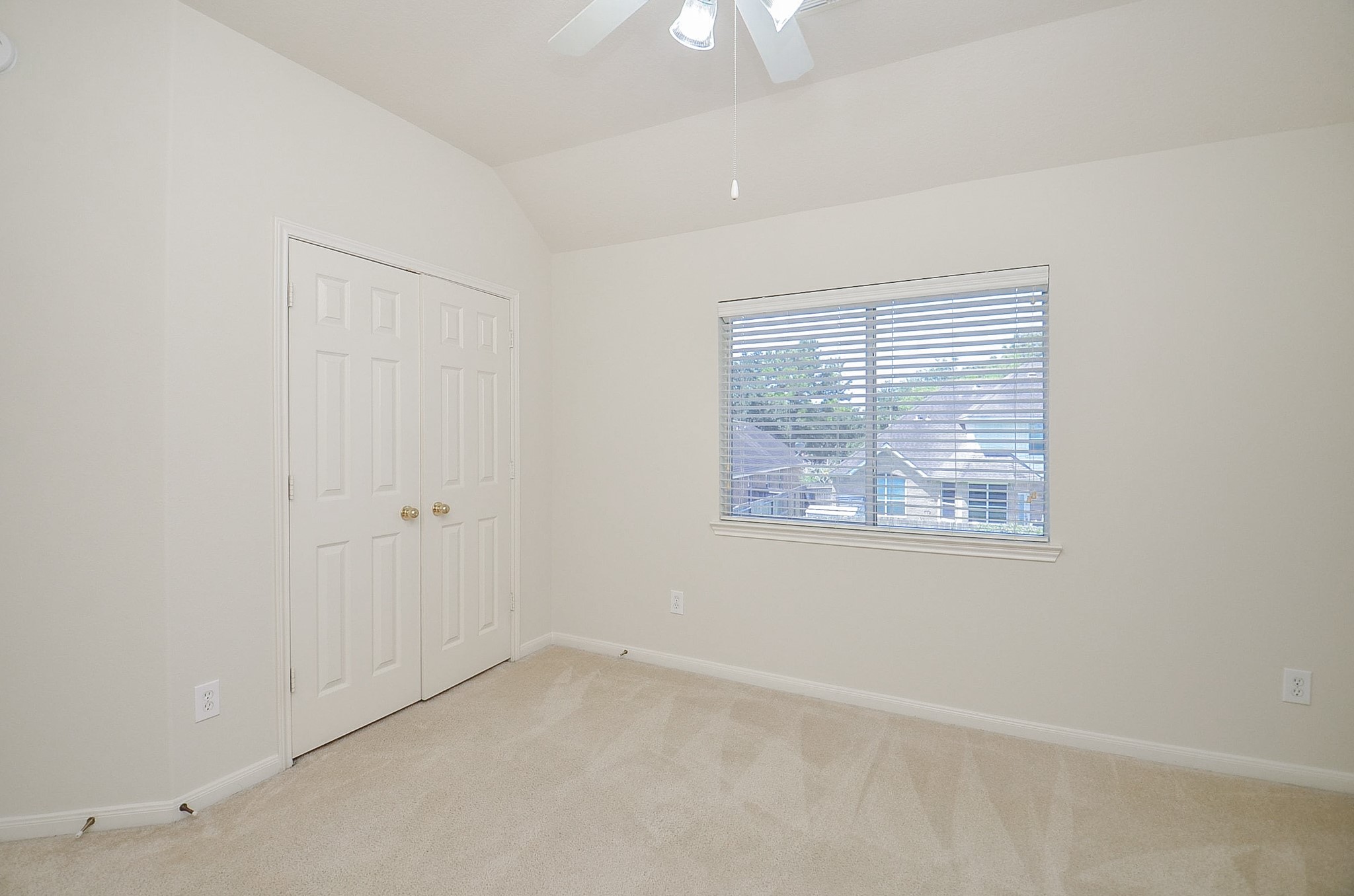 The second bedroom three offers a cozy retreat with abundant natural light and serene backyard views.
