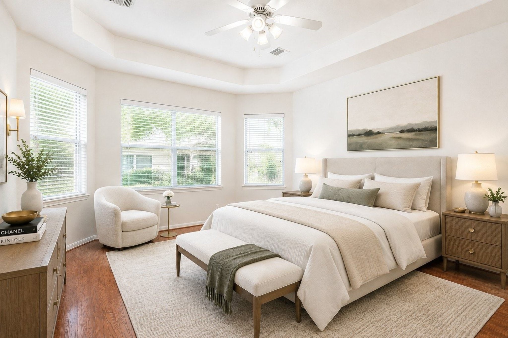 Experience the elegance of a virtually staged primary room, featuring a grand entrance with a stunning arched window and tray ceiling, welcoming you with warmth and style.