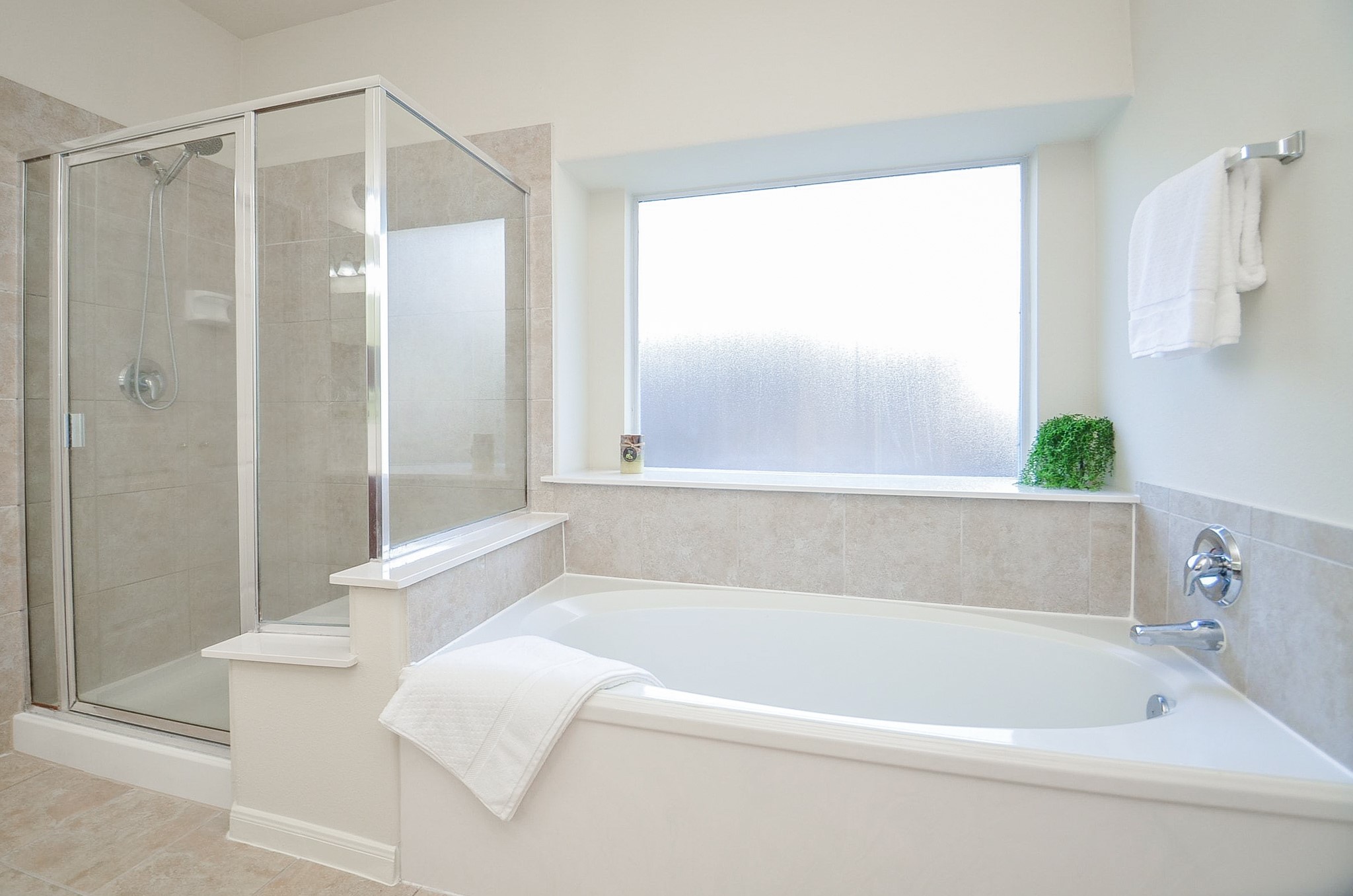 Experience the serene ambiance of this spacious primary bathroom, bathed in natural light and designed for ultimate relaxation.