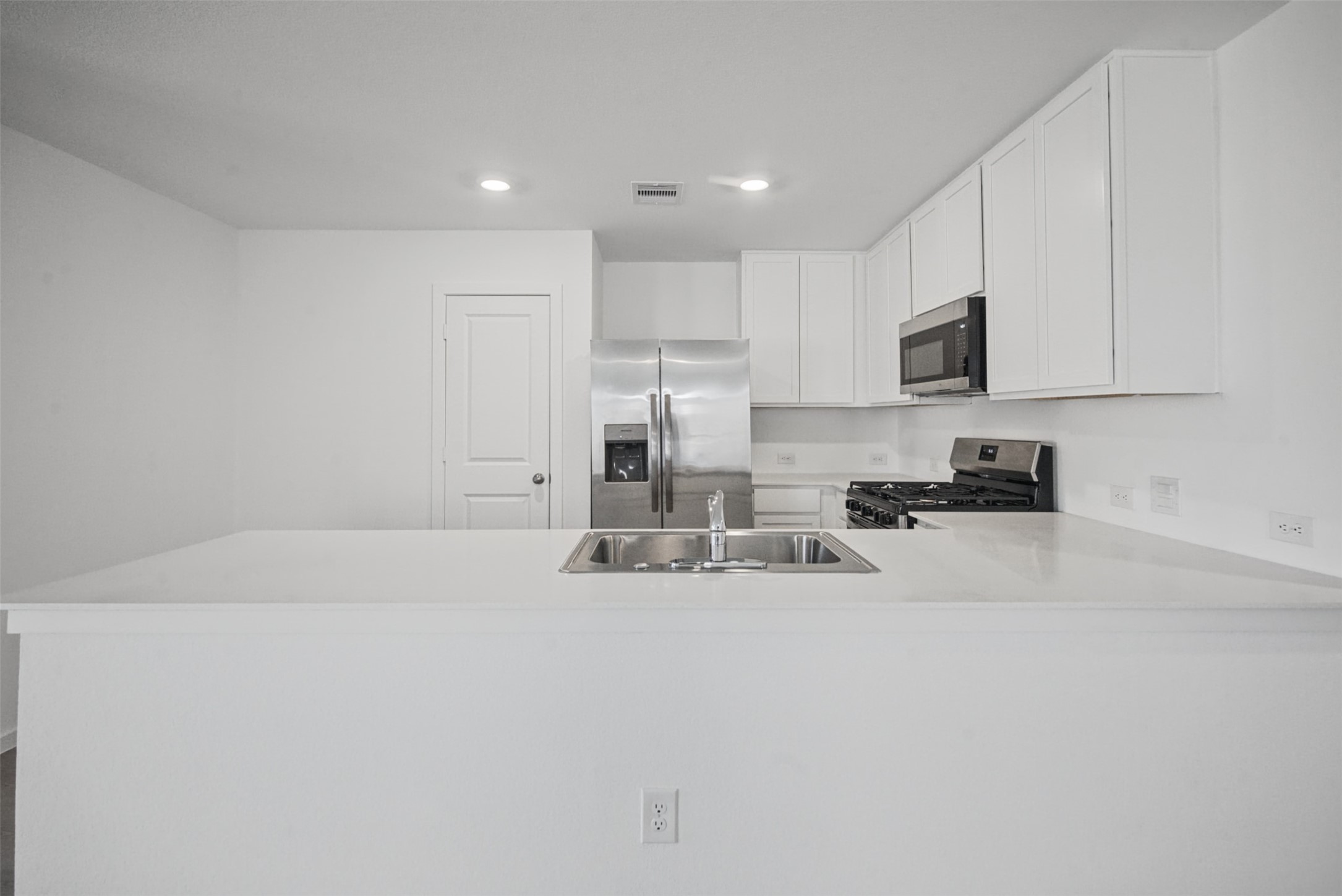 Clean, bright, and functional, this kitchen pairs abundant cabinetry and counter space with stainless steel appliances, making everything from quick breakfasts to dinner at home feel effortless.