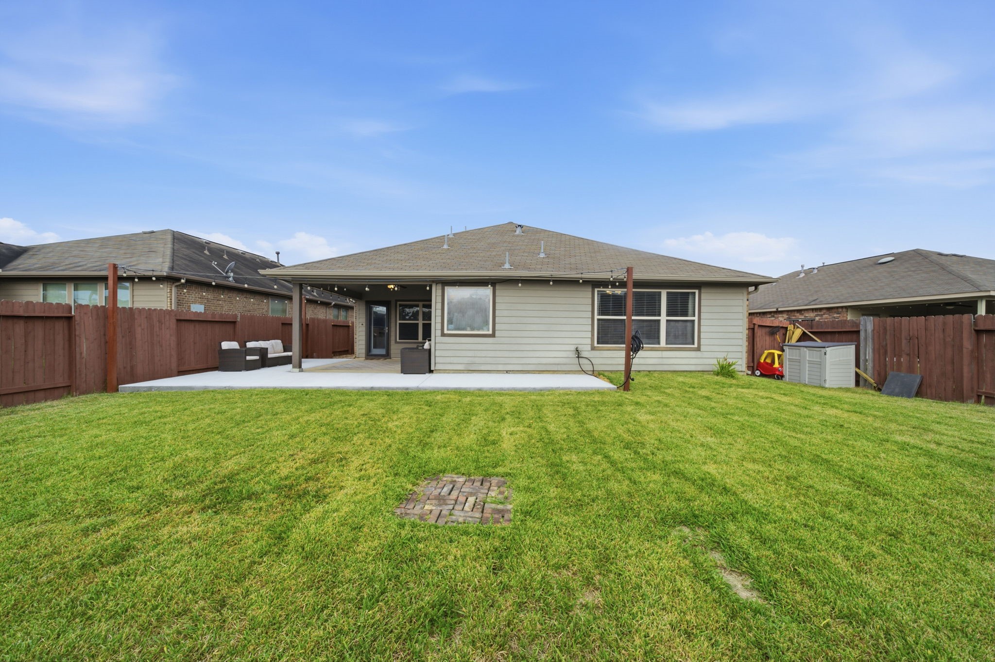 Spacious backyard with a well-maintained lawn, a large patio perfect for entertaining, and privacy fencing for a serene outdoor experience.