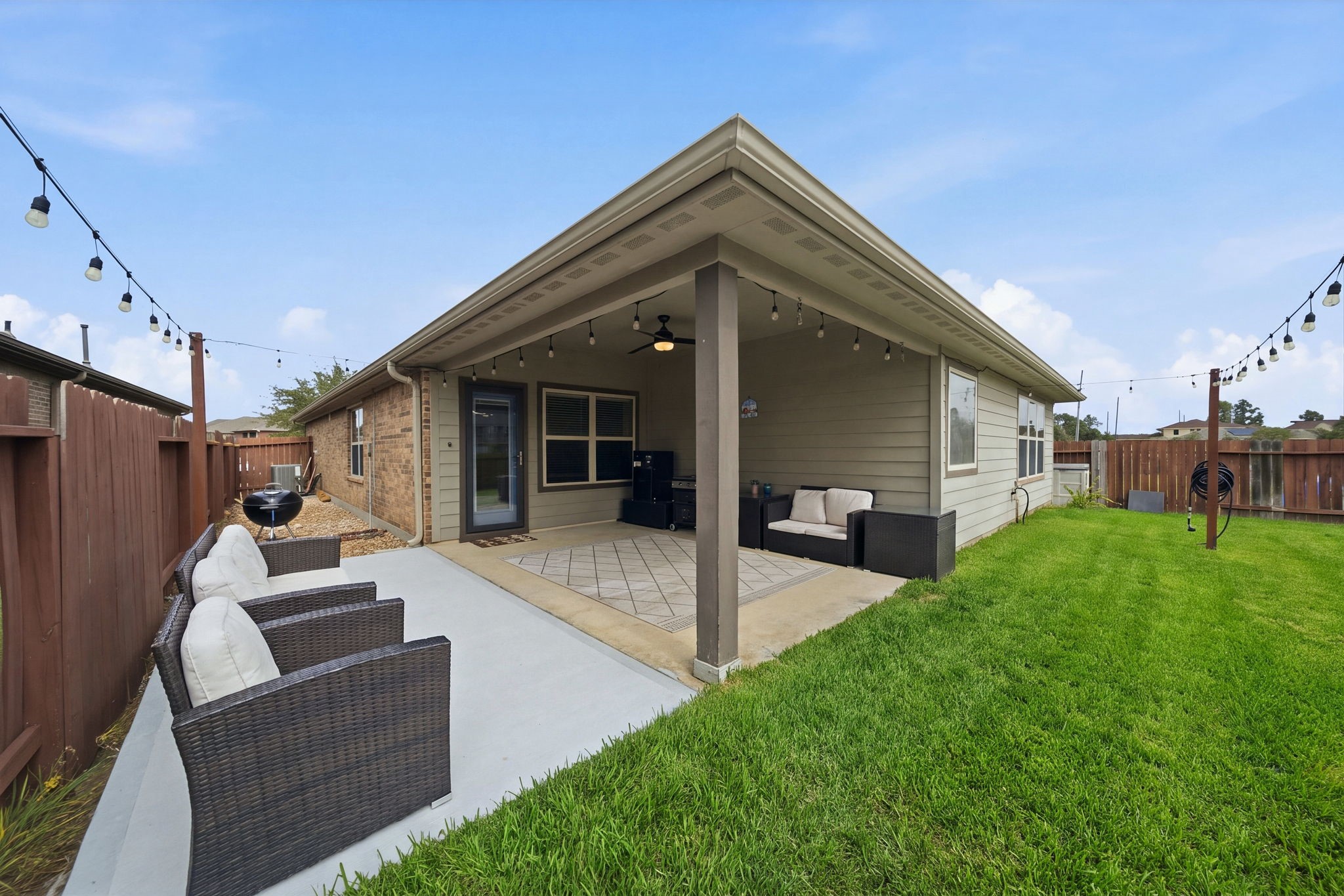 Charming backyard with a covered patio, cozy seating area, perfect for outdoor relaxation and entertainment.