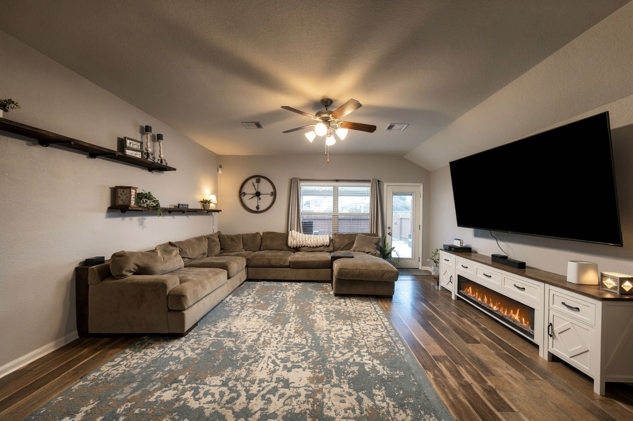 Spacious living room with elegant LVP flooring, a modern ceiling fan, and ample natural light through the rear windows. Spacious living room with elegant LVP flooring, a modern ceiling fan, and ample natural light through the rear windows.