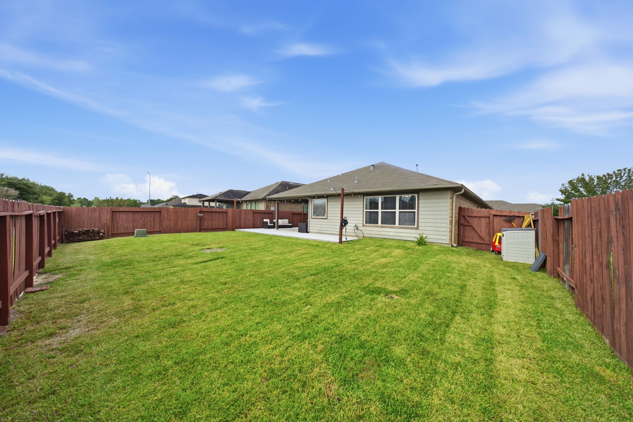 Spacious backyard with a well-maintained lawn, perfect for outdoor activities and entertaining, enclosed by a sturdy wooden fence for privacy.