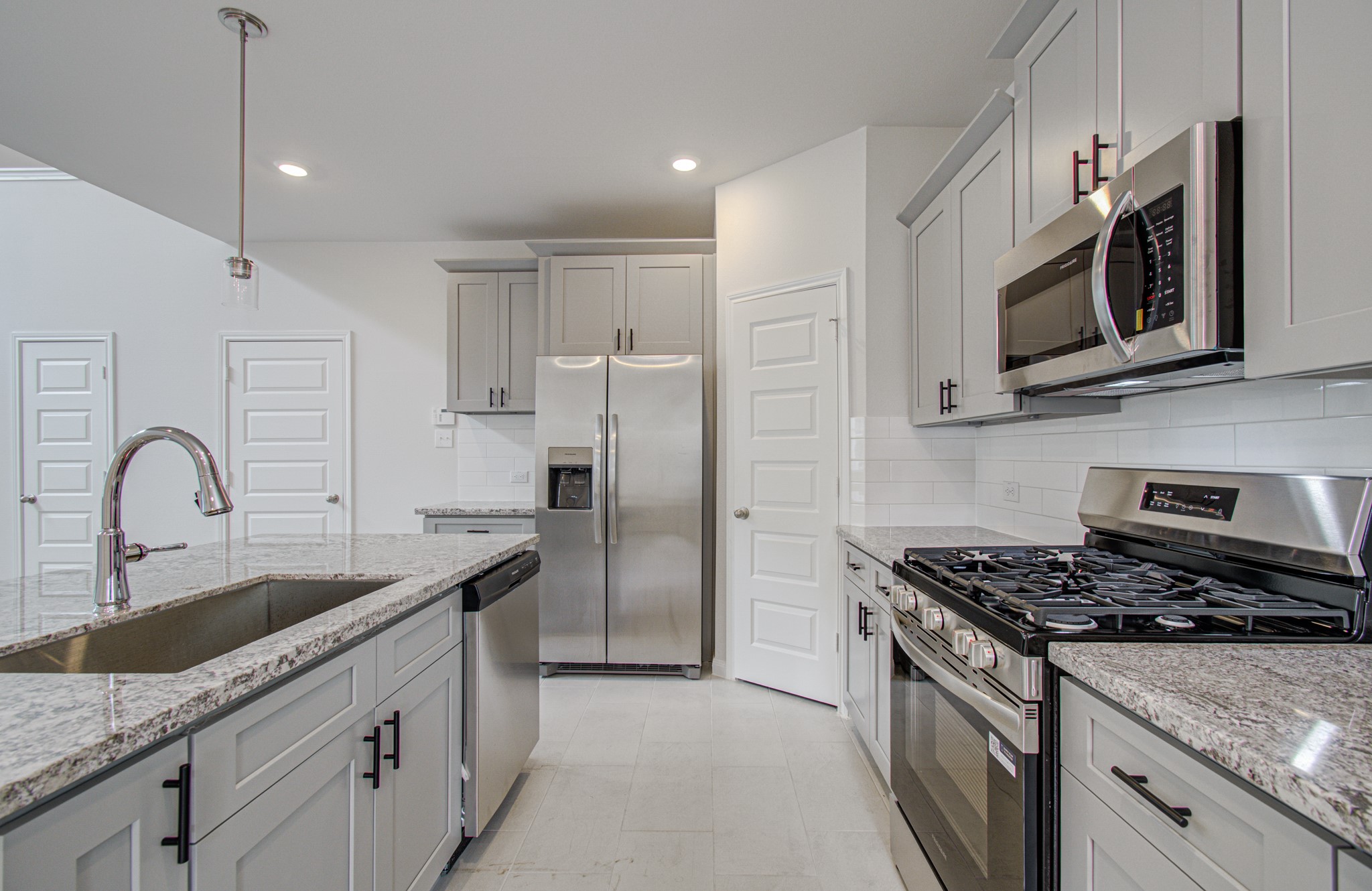 Modern kitchen featuring sleek stainless steel appliances, granite countertops, and ample cabinetry for storage. Please Note this is a different home/floorplan in the community.