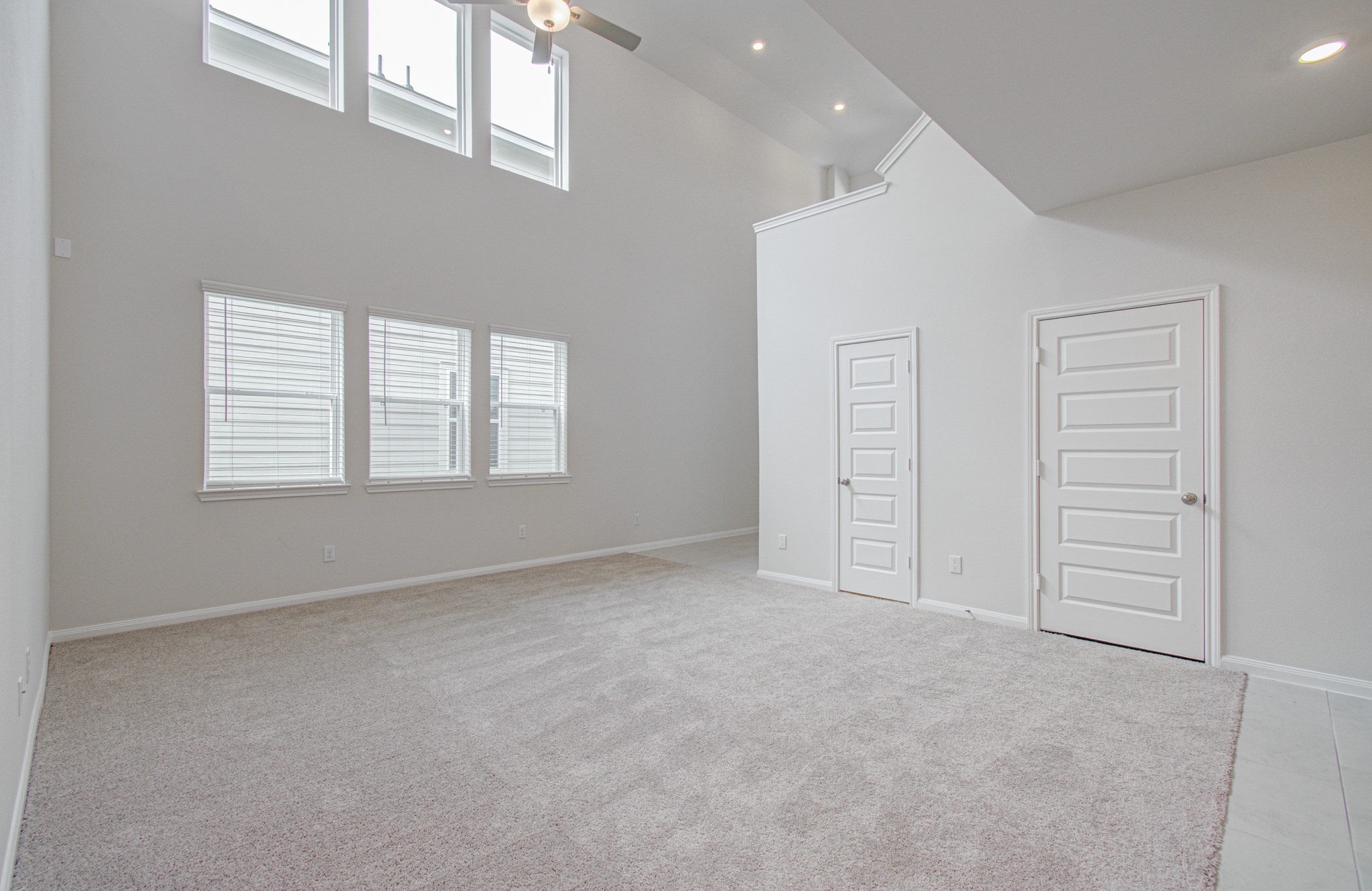Spacious living area with high ceilings, abundant natural light from large windows, and modern finishes for a bright, airy ambiance. Please Note this is a different home/floorplan in the community.
