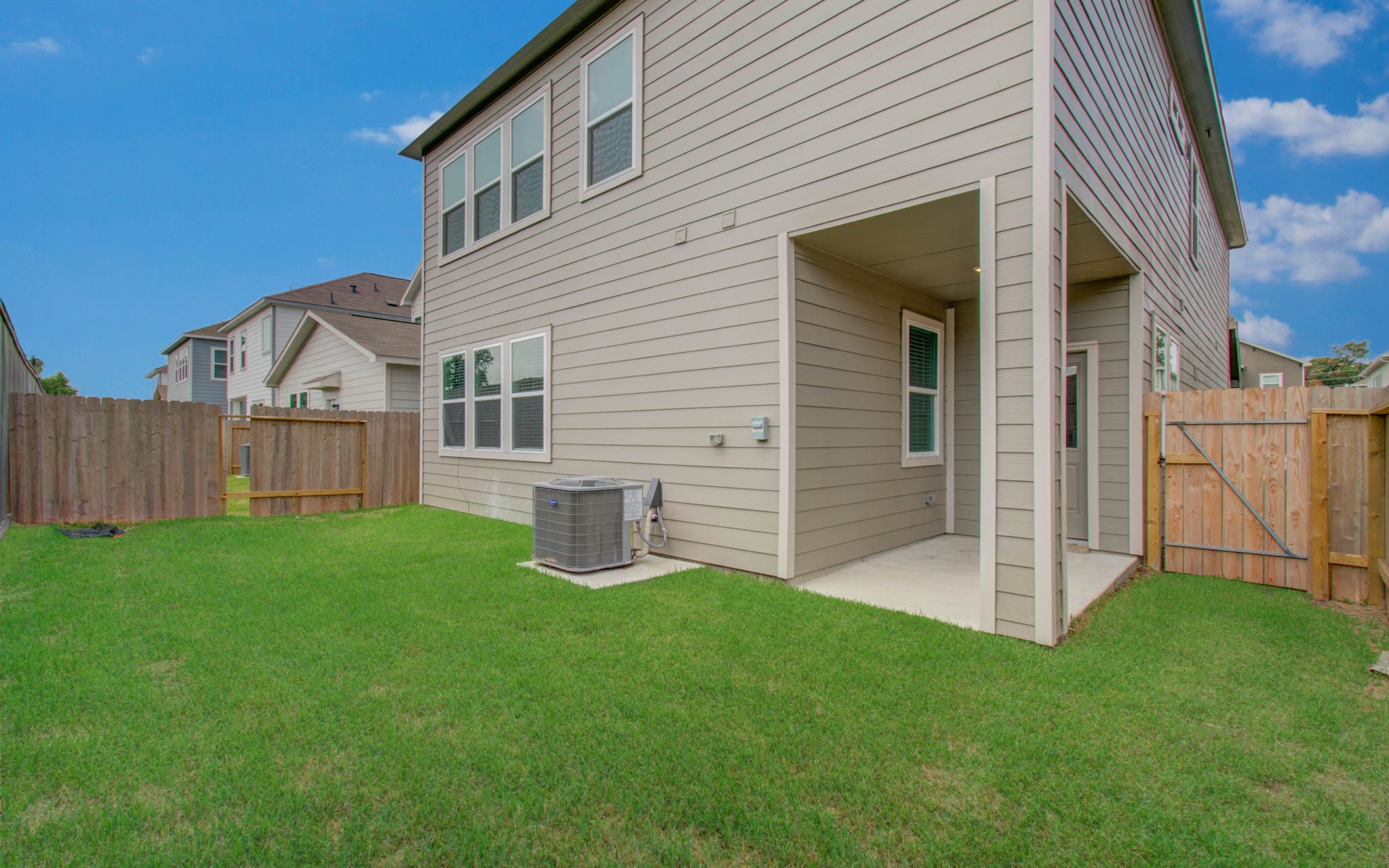 Spacious backyard featuring a covered patio, perfect for outdoor relaxation, with a well-maintained lawn and privacy fence. Please Note this is a different home/floorplan in the community.