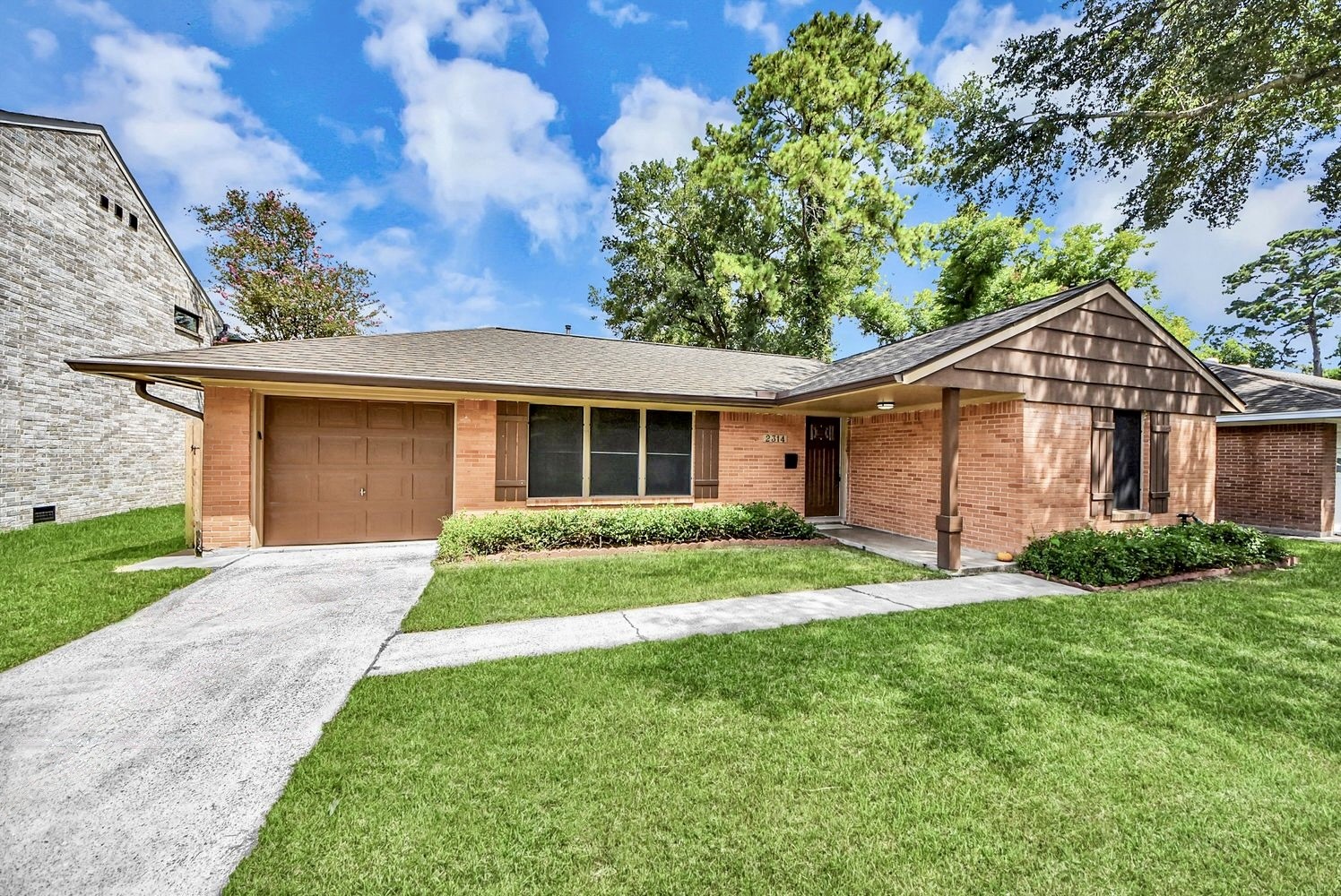 Home facade with driveway into attached garage. Home facade with driveway into attached garage.