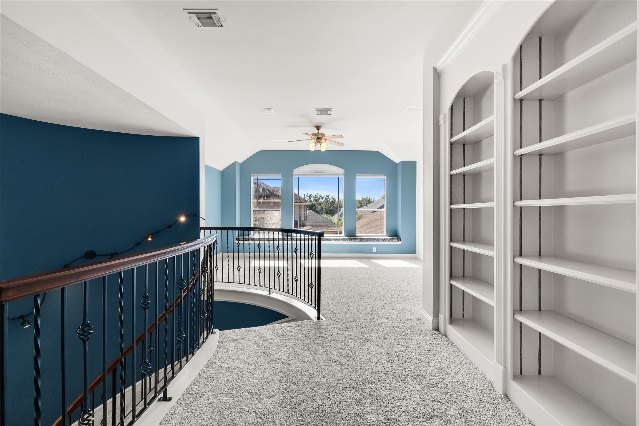 An inviting second-floor landing with built-in shelving and attractive architectural details connects the upstairs bedrooms and additional living spaces.