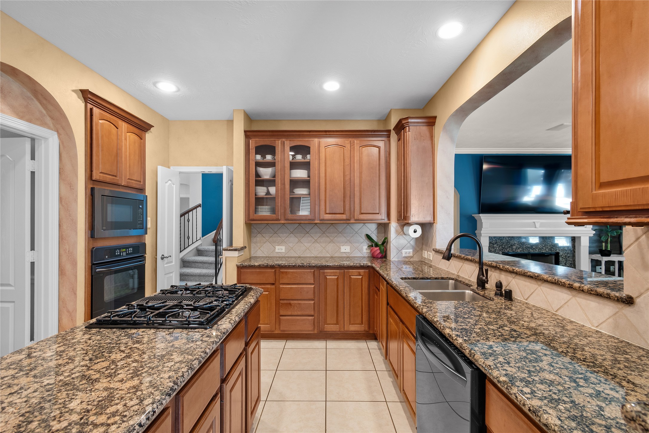 Designed with both entertaining and everyday cooking in mind, the kitchen features abundant cabinetry, granite counters, a gas cooktop and convenient workspace for meal preparation.