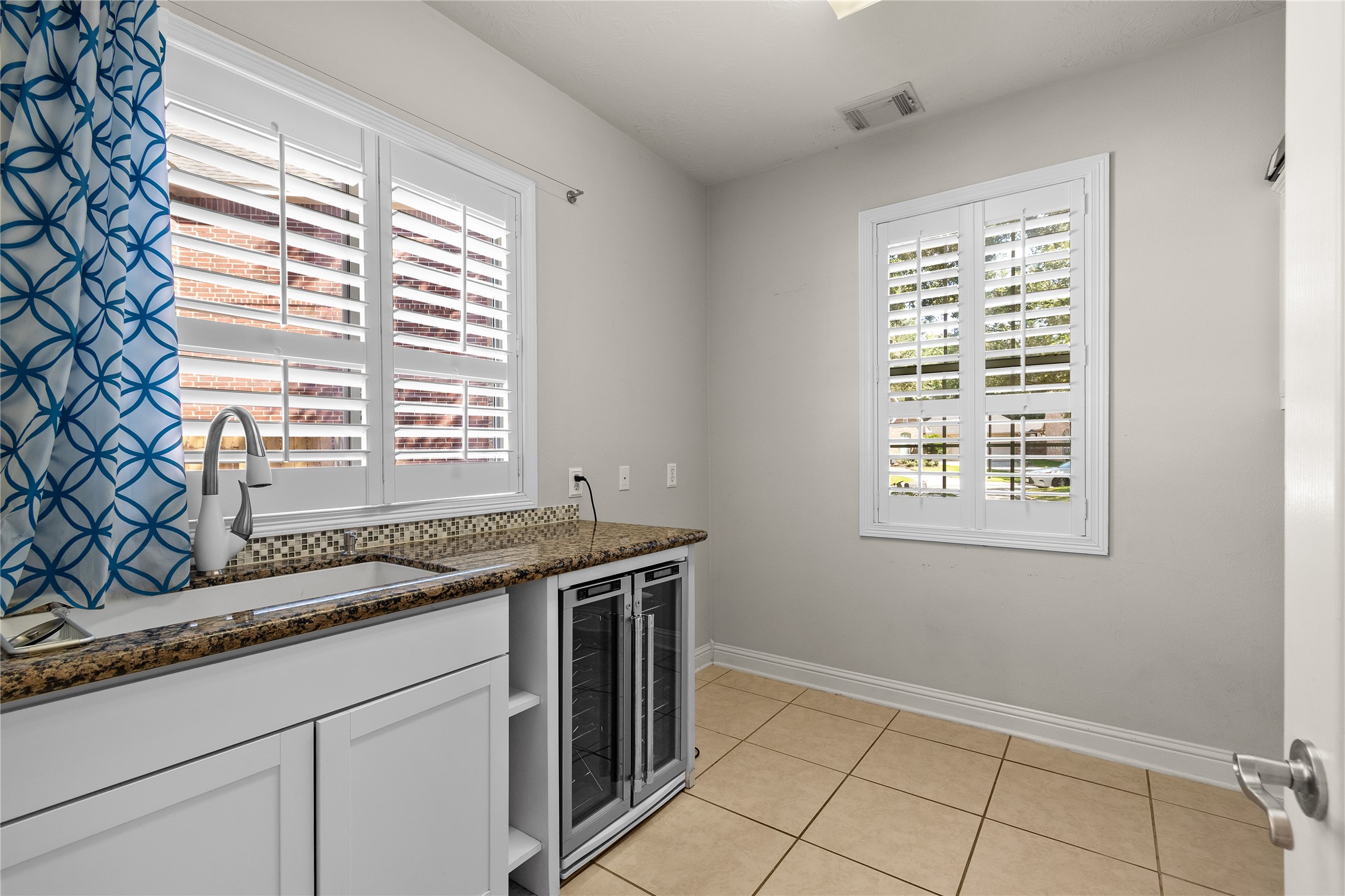 A spacious utility room with built-in cabinetry, a countertop workspace and natural light makes everyday household tasks more organized and convenient.