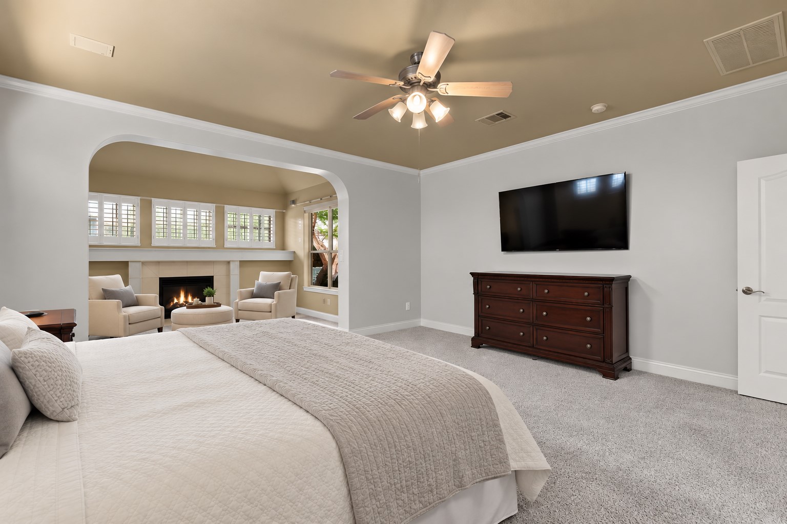 Escape to this inviting first-floor primary suite, featuring a ceiling fan, generous room dimensions and an adjoining sitting area with its own fireplace for added comfort.**Virtually Staged**