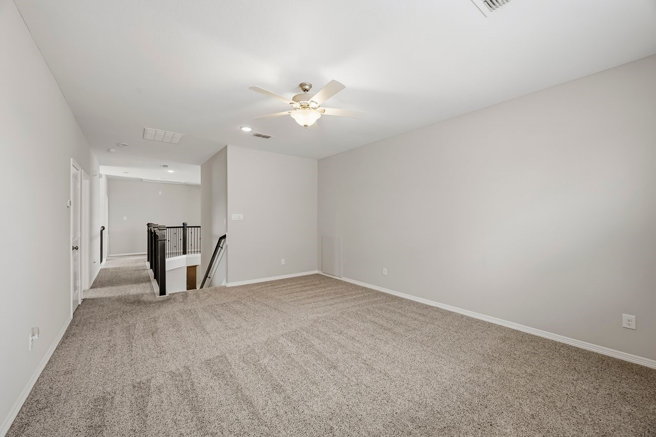 Ascend to the second floor to find an expansive game room designed for versatility. A sleek catwalk connects the space to three secondary bedrooms, including a private guest suite with a full bath and two additional bedrooms joined by a well-appointed Jack-and-Jill bathroom featuring separate vanities.