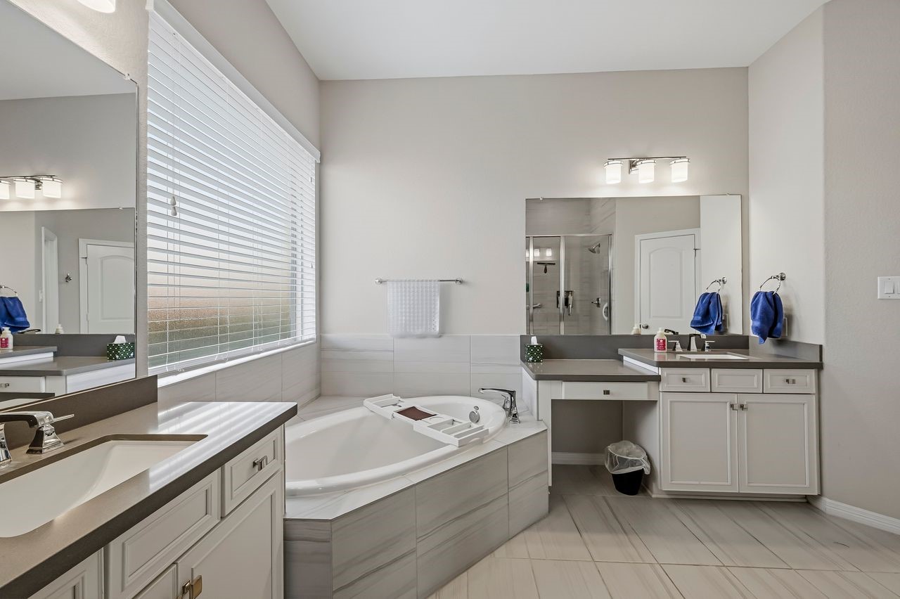 This expansive primary ensuite offers a refined retreat, anchored by dual vanities topped with sleek quartz. The oversized mirror and a soft, neutral palette enhance the sense of light and airy sophistication.