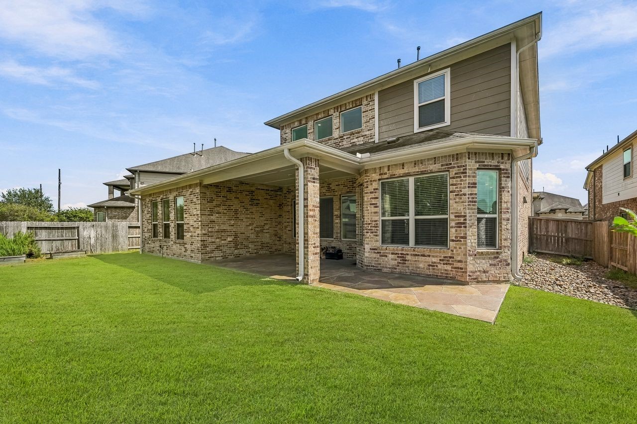 A refined perspective of the rear exterior, highlighting the expansive proportions of the custom-tiled patio.