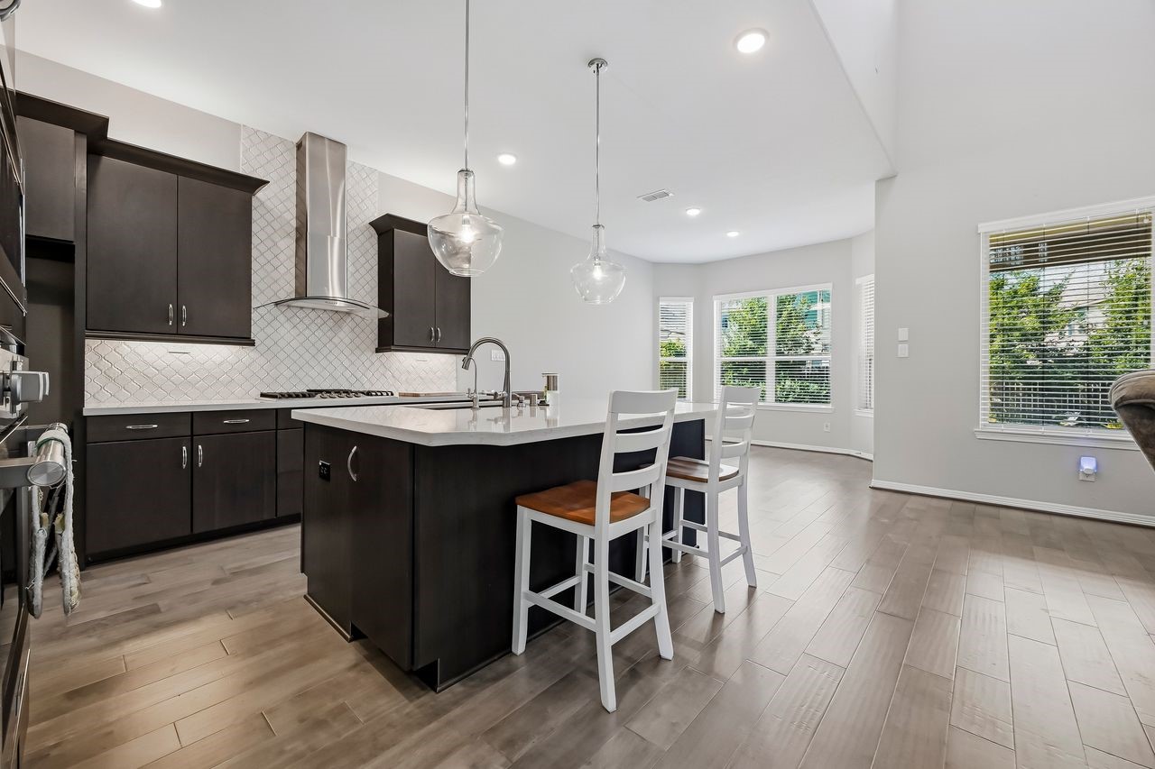 From the base of the stairs, the view opens to a sophisticated kitchen and breakfast bay. The seamless blend of contemporary finishes and abundant natural light creates a refined setting for hosting and gathering.