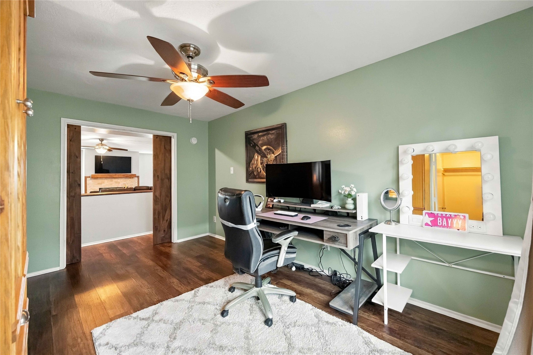 Alternate view highlights the spacious secondary bedroom and distinctive sliding barn-door entry connecting to the main living area.