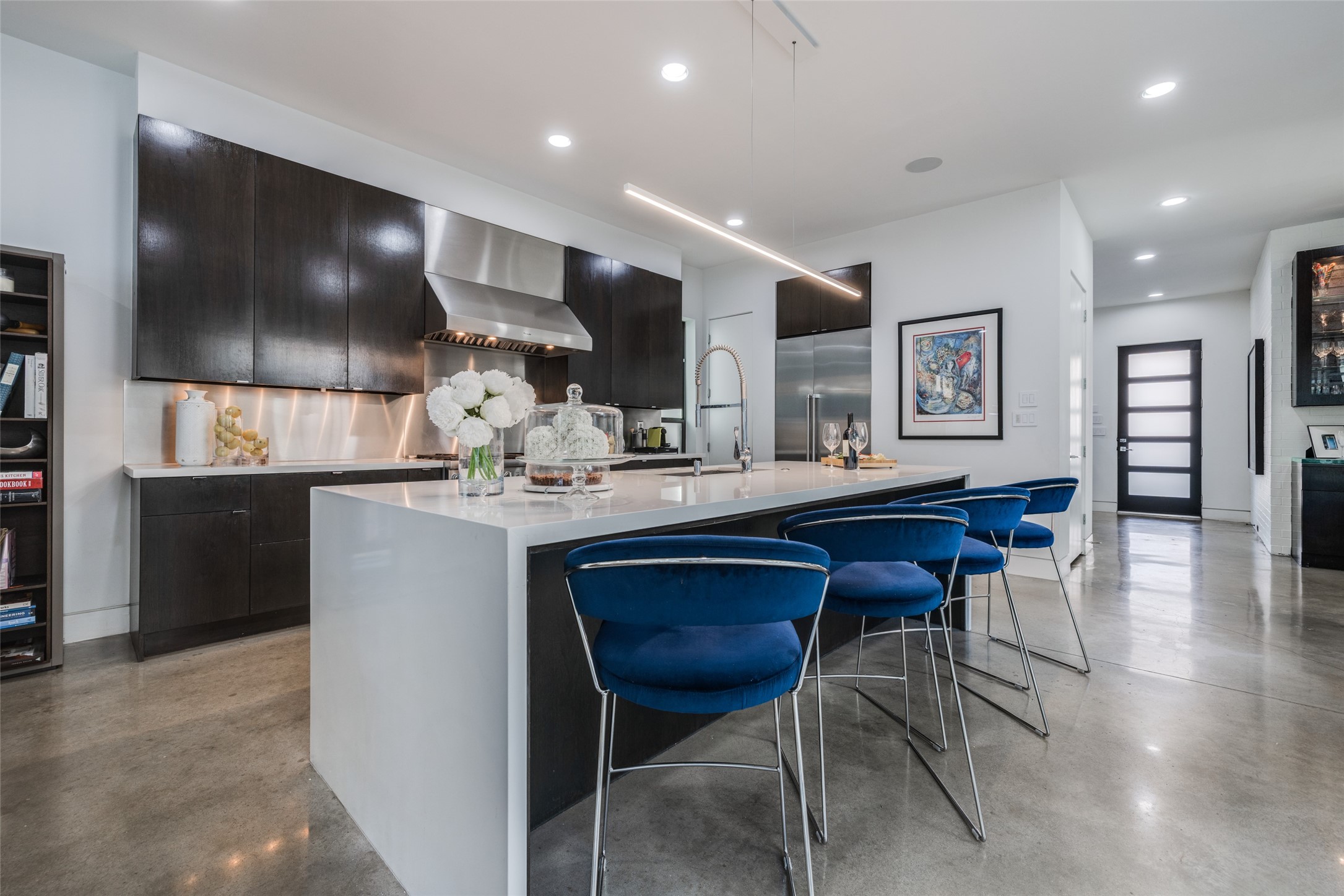 Large Thermador SS refrigerator, large walk in pantry & extra storage from the elevator shaft cupboards, beautiful designer pendant lighting, large island with quartz waterfall edge, 10 ft ceiling.