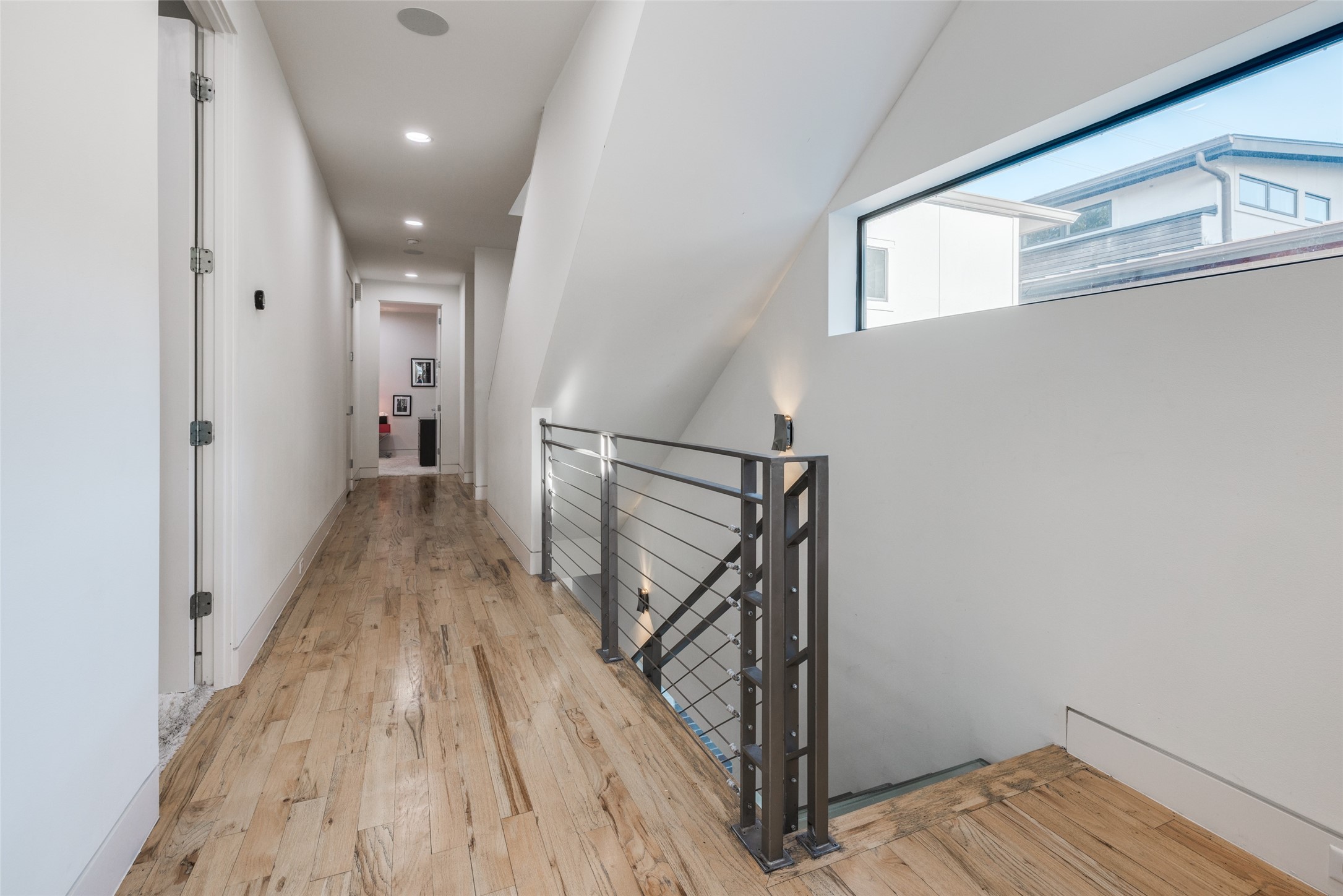 Second floor corridor leads to 3 bedrooms, including Primary Suite & utility room  - warm hard wood floors - lots of natural light, downstairs has second office space.