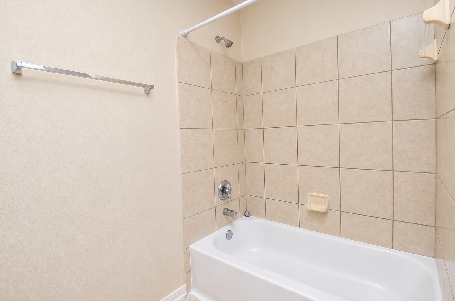 Upstairs bathroom with a tub/shower combination, tiled surround and convenient built-in soap dish.