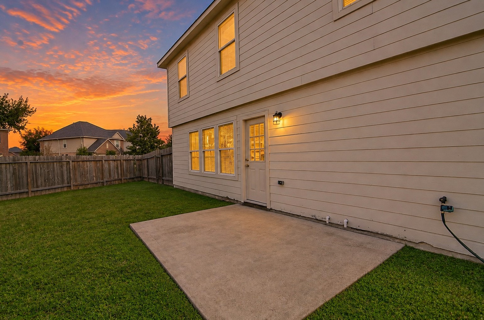 Concrete backyard patio offers a convenient space for outdoor seating, grilling or relaxing in the evenings.