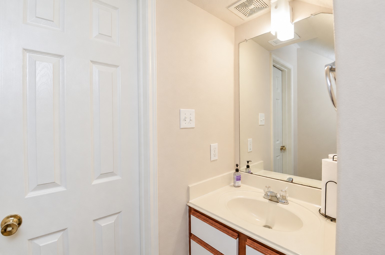Additional view of the first-floor half bath featuring a spacious vanity, large mirror and convenient access from the main living area.