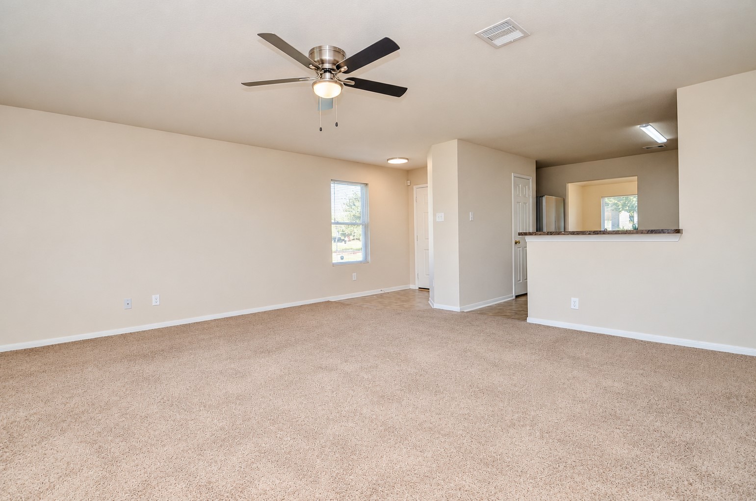 Additional view of the spacious family room, highlighting the open layout and convenient access to the kitchen and dining areas.