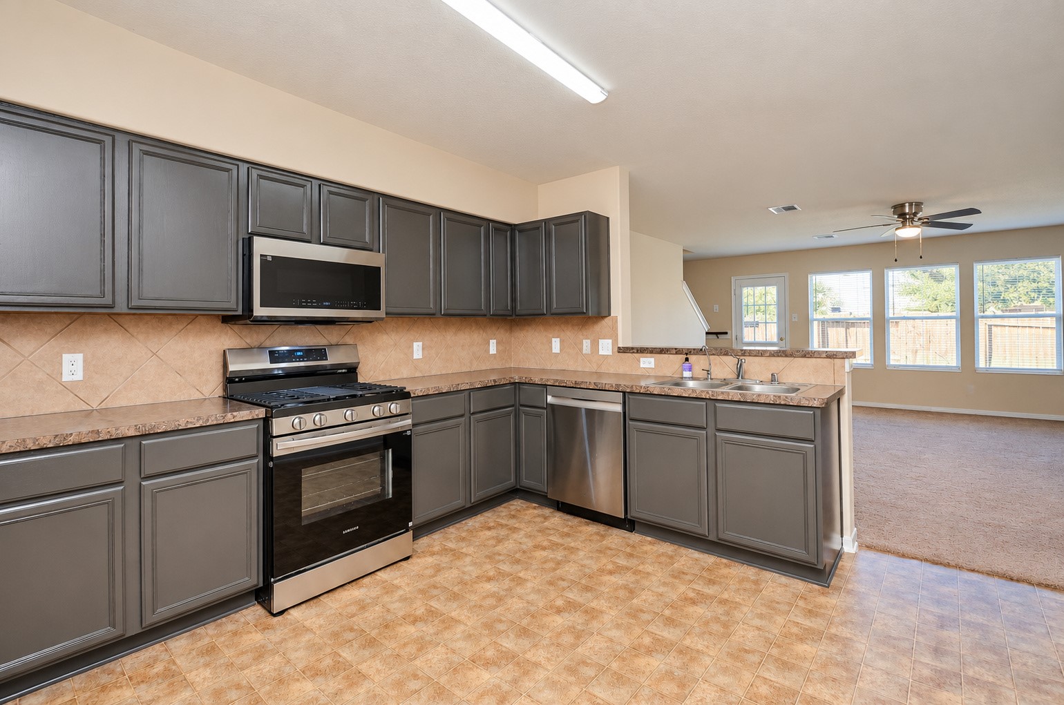 Open kitchen layout featuring stainless steel appliances, ample storage and a breakfast bar overlooking the family room.