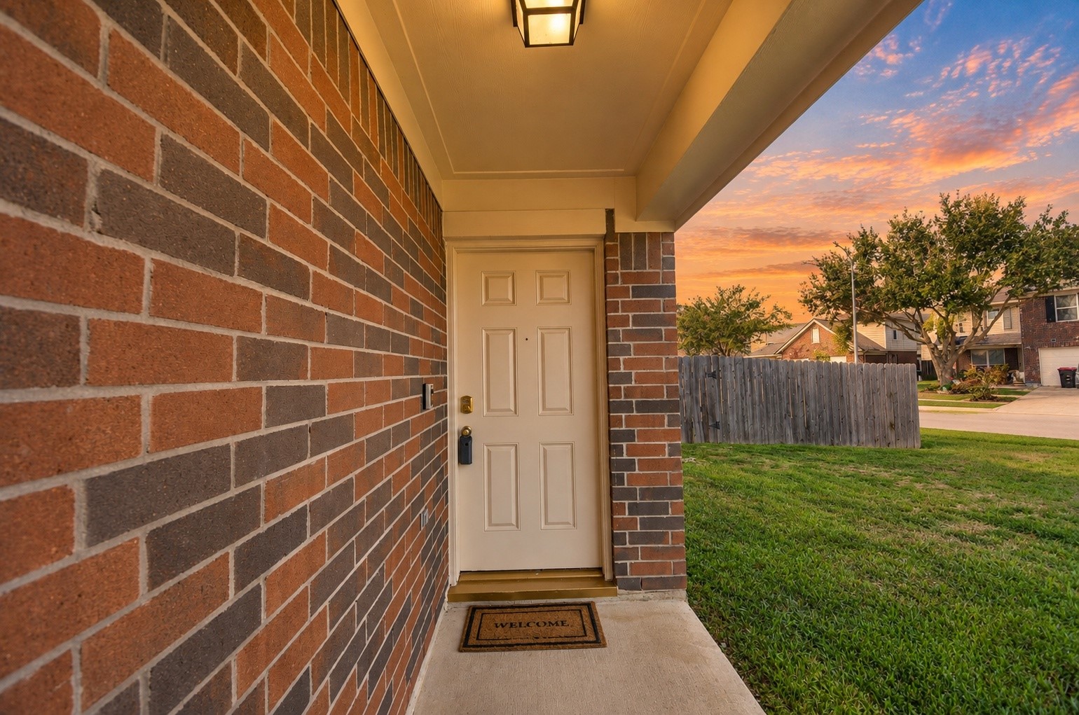 Covered front entry with brick accents and a welcoming approach to the home.