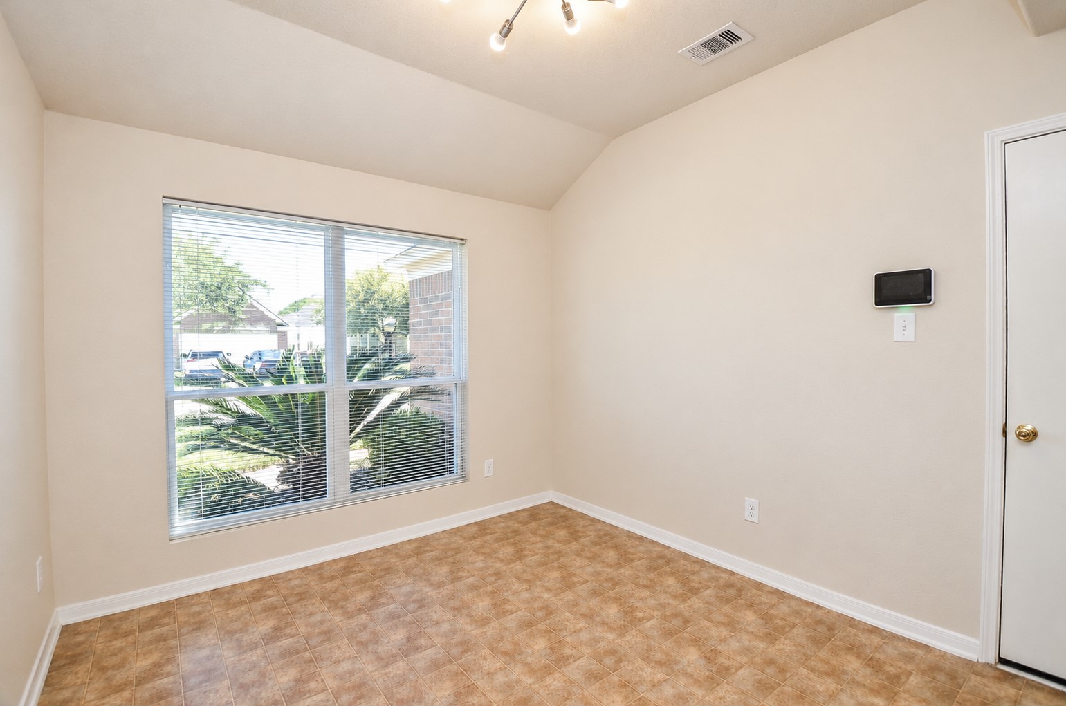 Formal dining room featuring a large window, vaulted ceiling and natural light, ideal for everyday dining or entertaining.