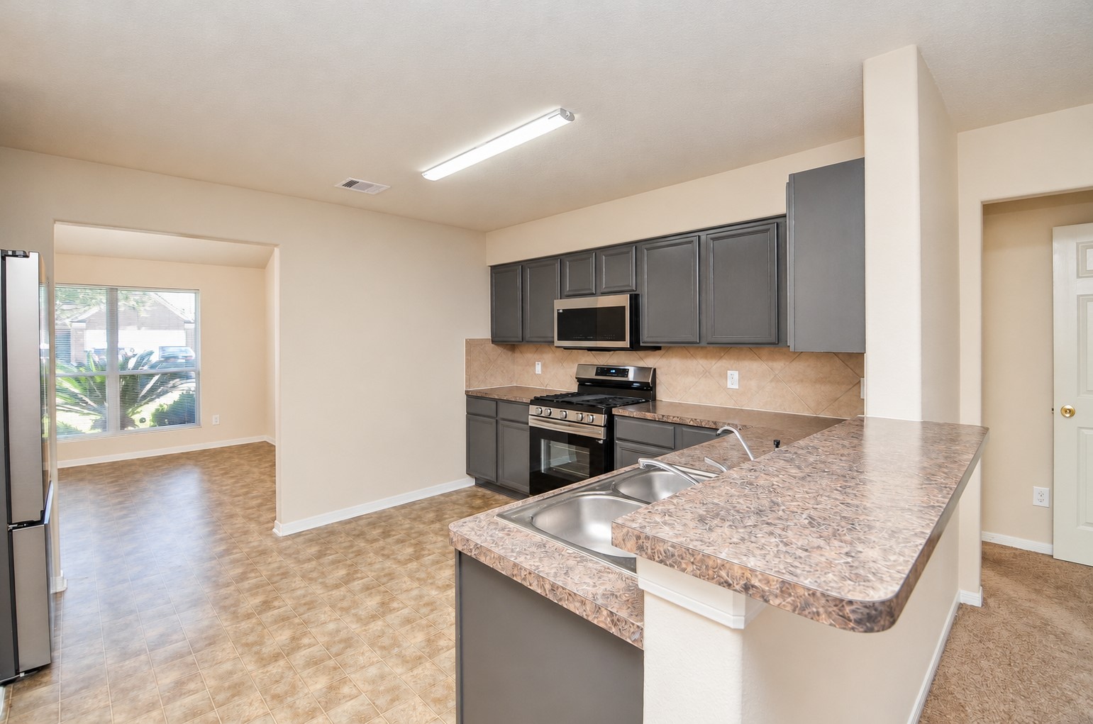 Kitchen featuring generous counter space, ample cabinetry, a breakfast bar and convenient access to the formal dining room.