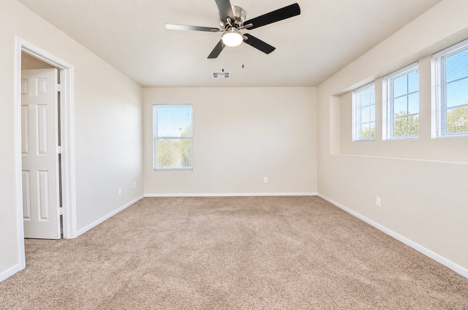 Additional view of the oversized upstairs bedroom highlighting its generous dimensions and multiple windows.