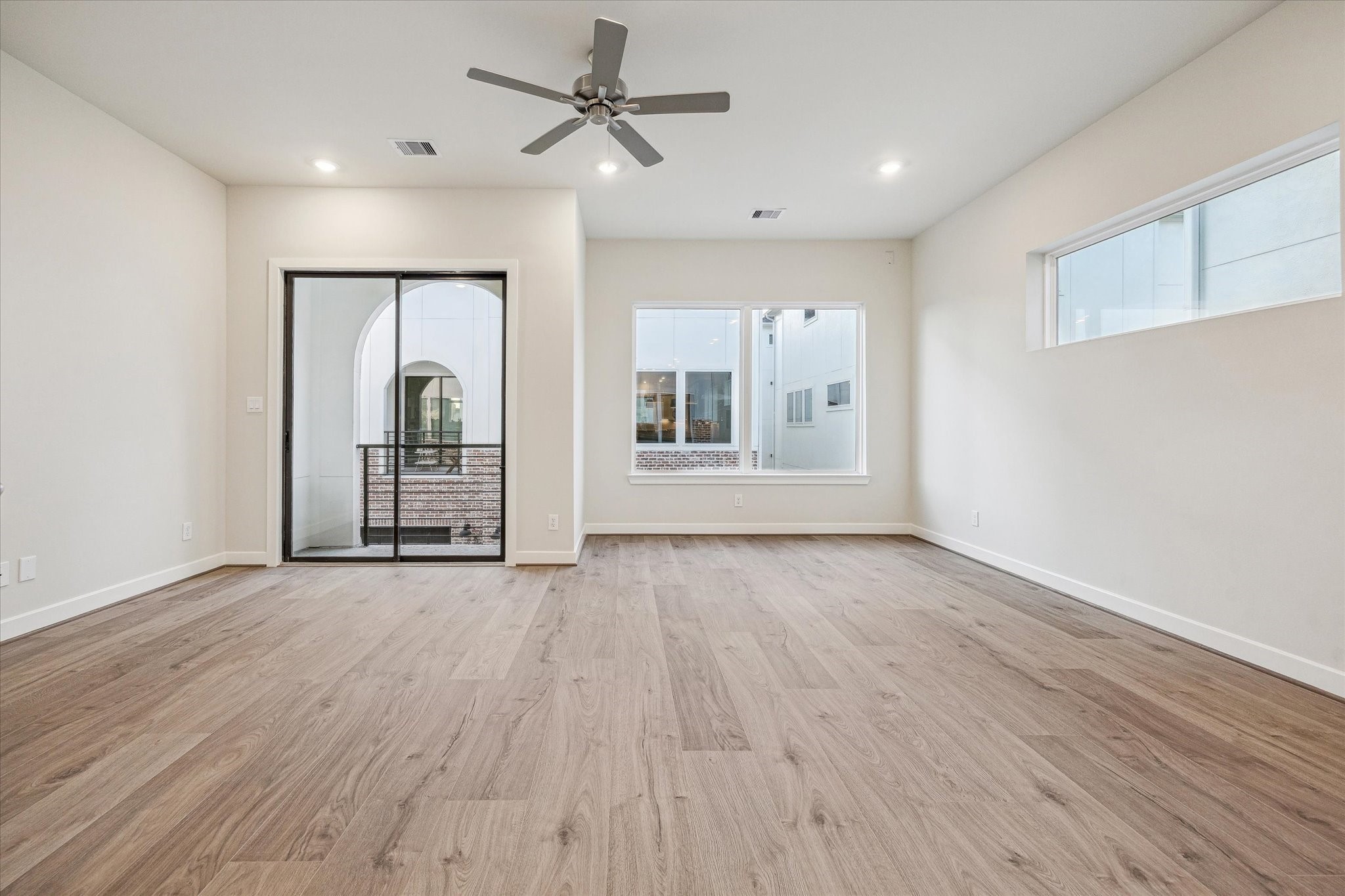 Spacious second-floor living area featuring a private balcony just off the main living space.
