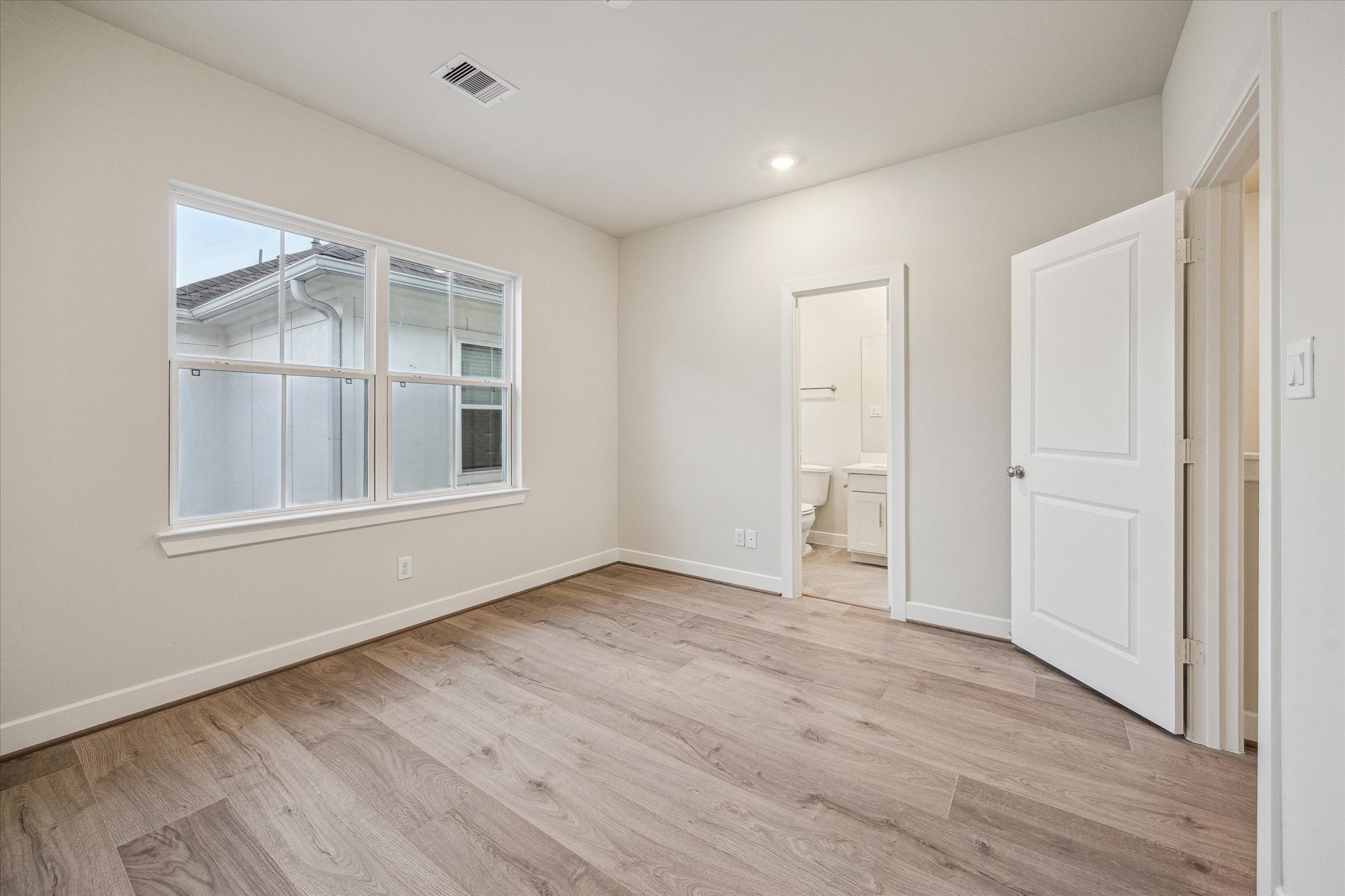 Secondary bedroom featuring large window, and direct access to a private en-suite bath.