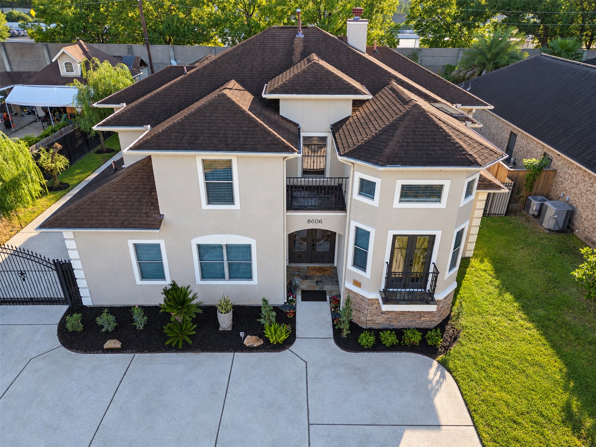 Front Exterior: Distinctive two-story architecture with an elegant stucco faade, stone accents, and two balconies that create striking curb appeal.