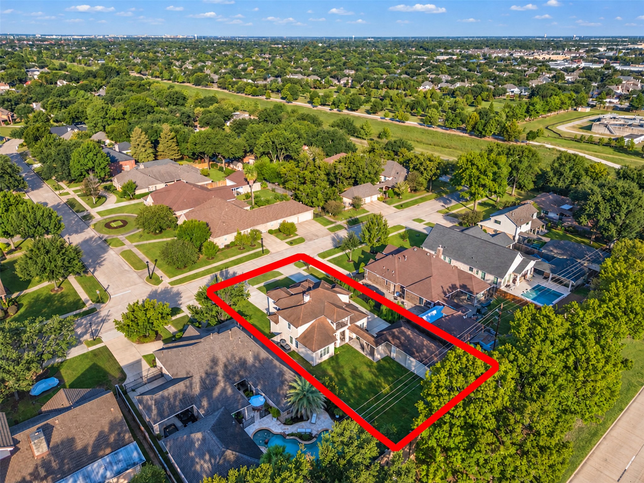 Aerial view showcasing the homes distinctive architecture, spacious lot, detached garage, and generous driveway parking.