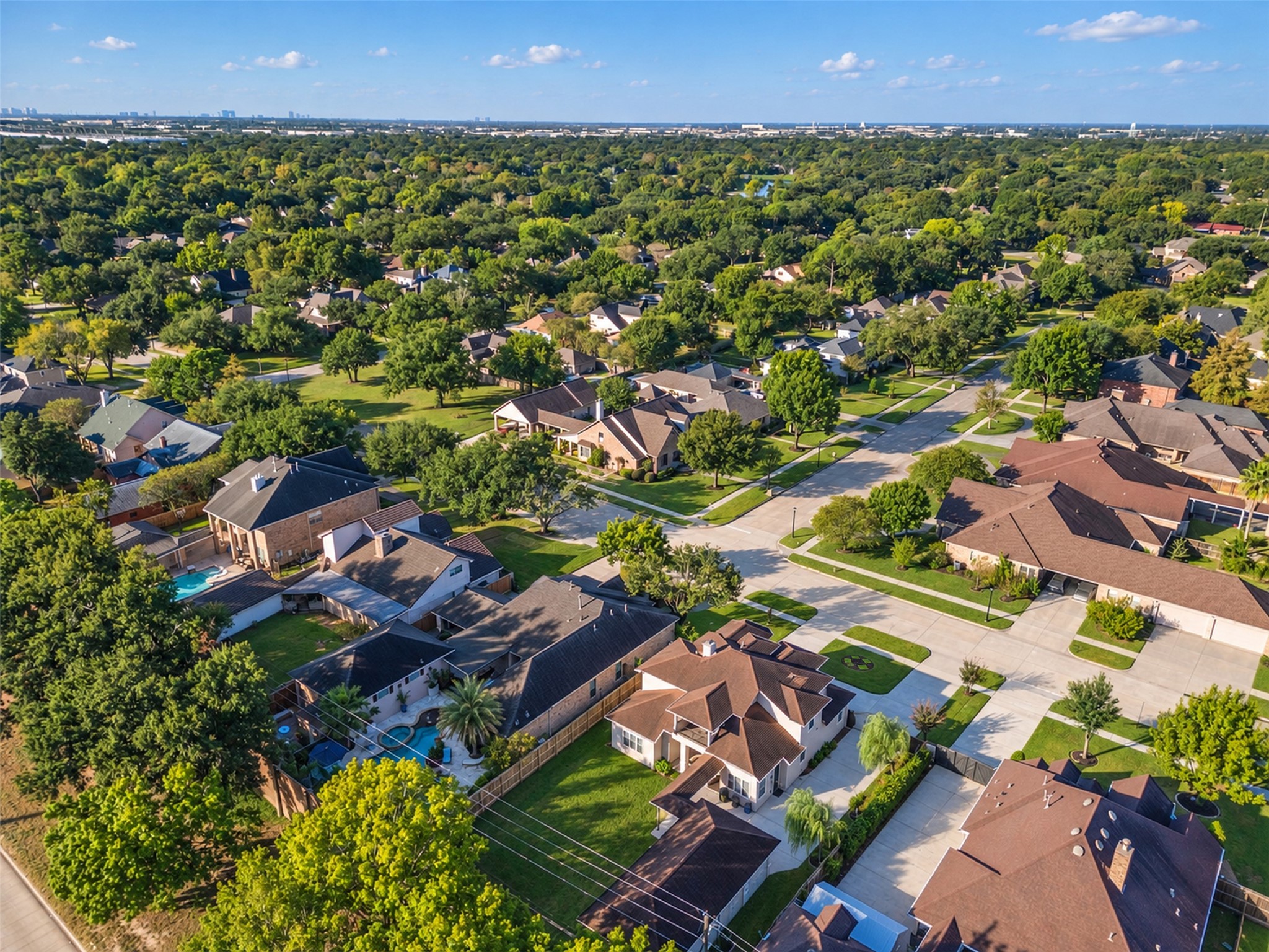 Aerial view showcasing the homes distinctive architecture, spacious lot, detached garage, and generous driveway parking.
