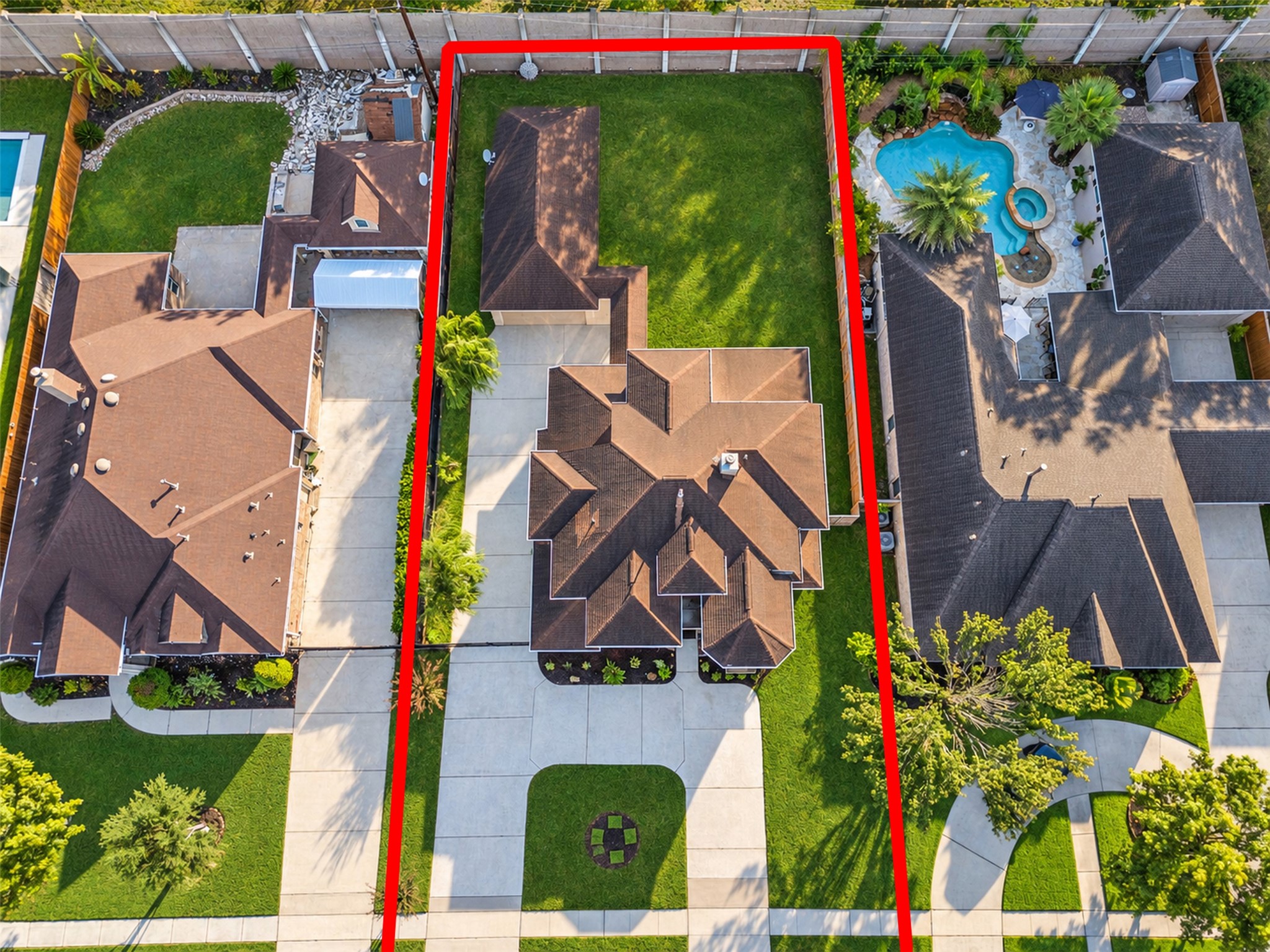 Aerial view showcasing the homes distinctive architecture, spacious lot, detached garage, and generous driveway parking.